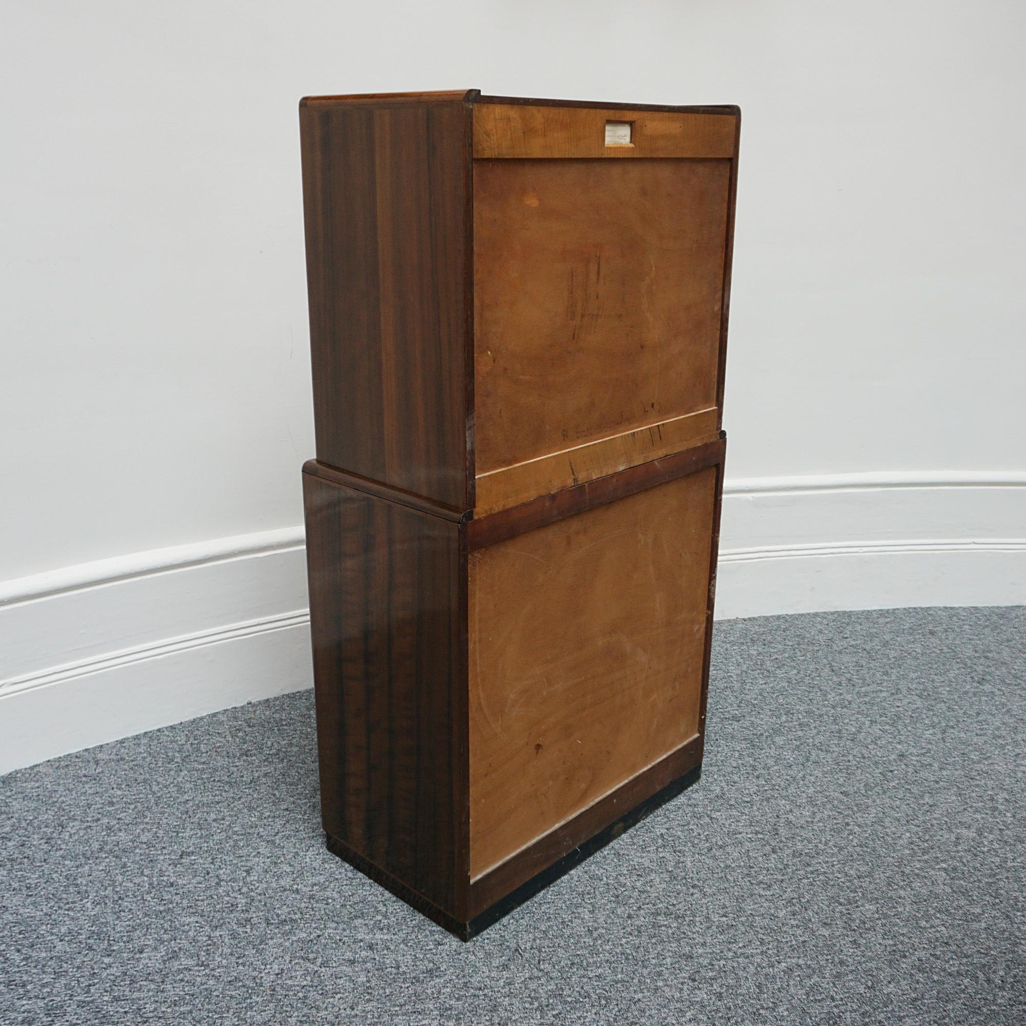 An Art Deco Linen cupboard by Betty Joel. Australian walnut veneered on mahogany with satin birch interior. Upper cupboard section with shelved interior and lower three pull out drawers. Original chrome handles. Designer and makers label to the