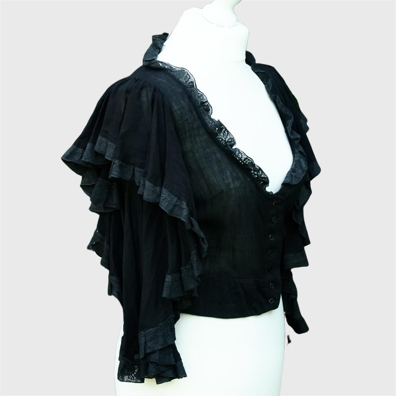 Grazioso top originale di Biba in mussola di cotone nero con bottoni sul davanti e maniche svasate graduate. Le maniche e il davanti sono ornati di pizzo nero. Il top è in ottime condizioni. Prodotto in India.

Questo è un top Biba davvero elegante