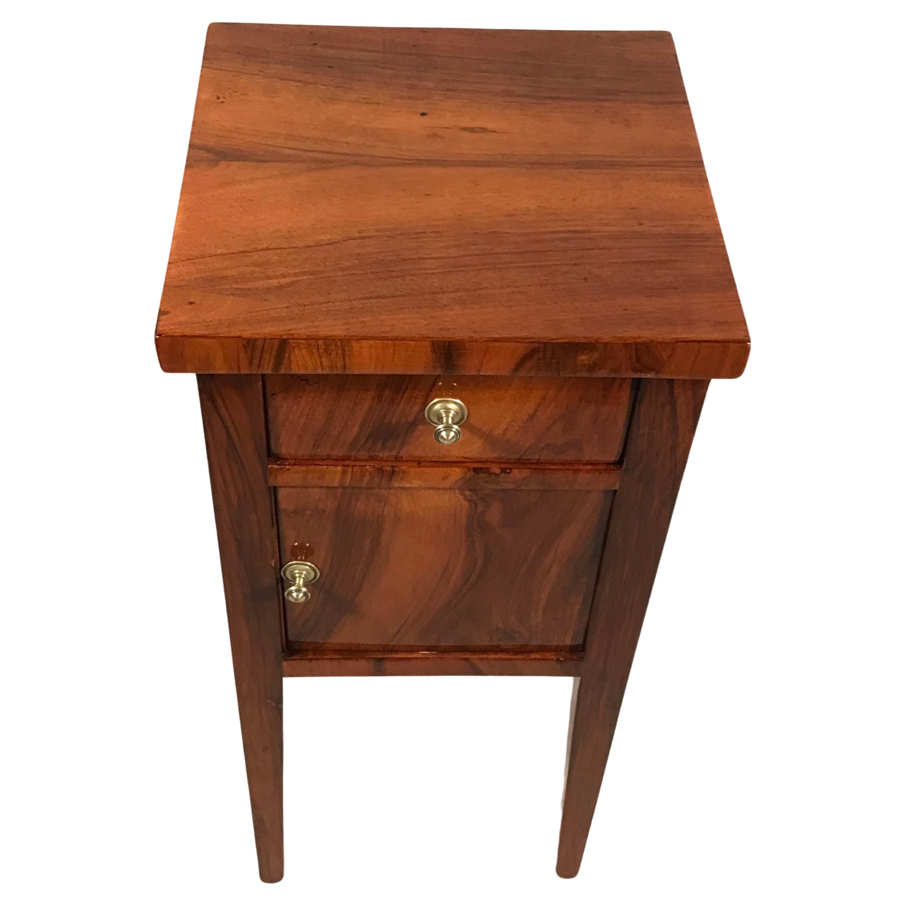 Entdecken Sie einen exquisiten, originalen Biedermeier-Nachttisch aus Süddeutschland, der aus dem Jahr 1820 stammt. Dieses elegante Stück zeichnet sich durch ein geradliniges Design aus, das auf allen vier Seiten mit wunderschönem Walnussfurnier