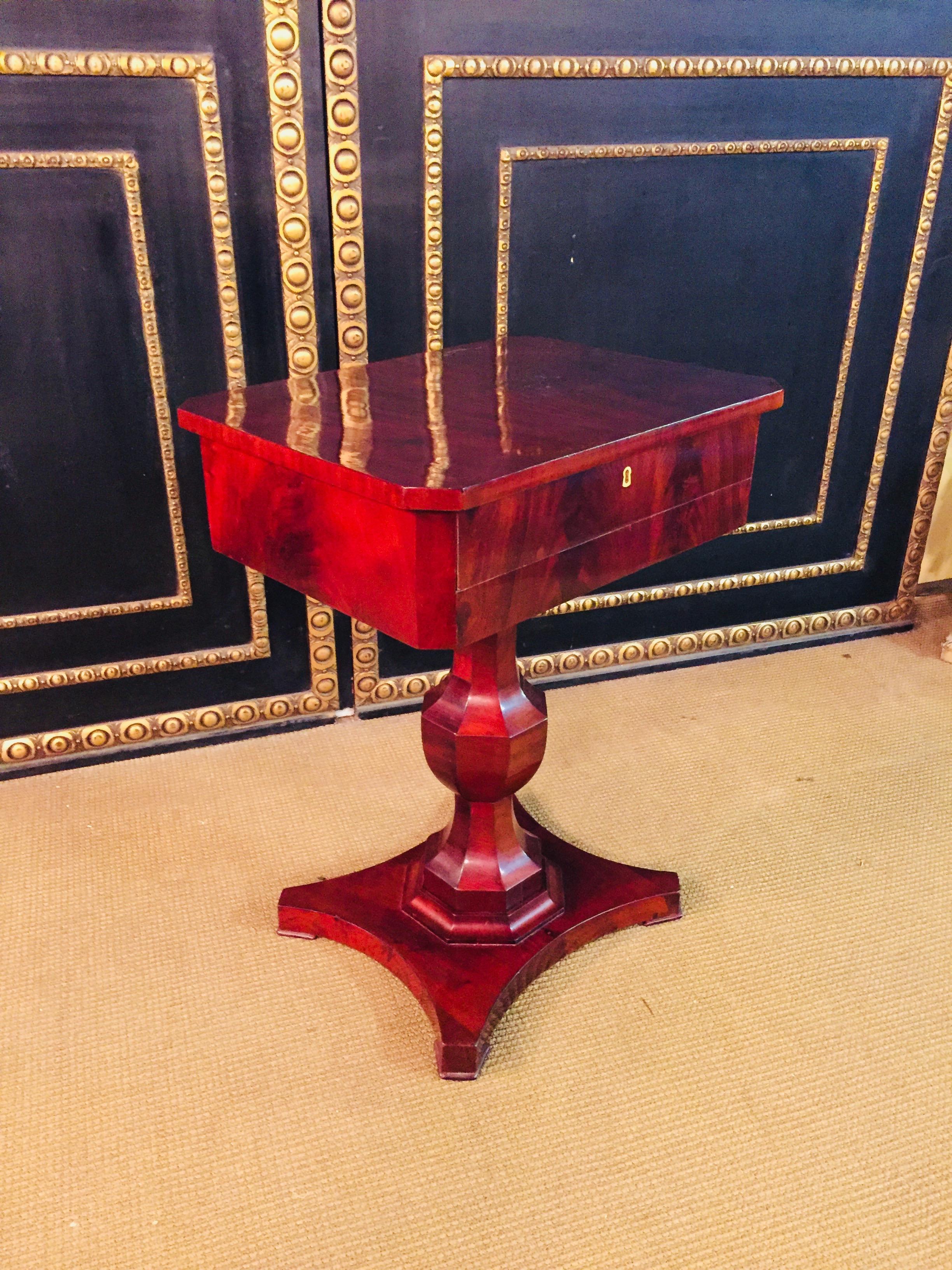 Original Biedermeier sewing table, circa 1825. Mahogany on solid softwood. Straight, two-handed frame box column on saber-4 legs. Four-sided tabletop in compartments for sewing utensils.