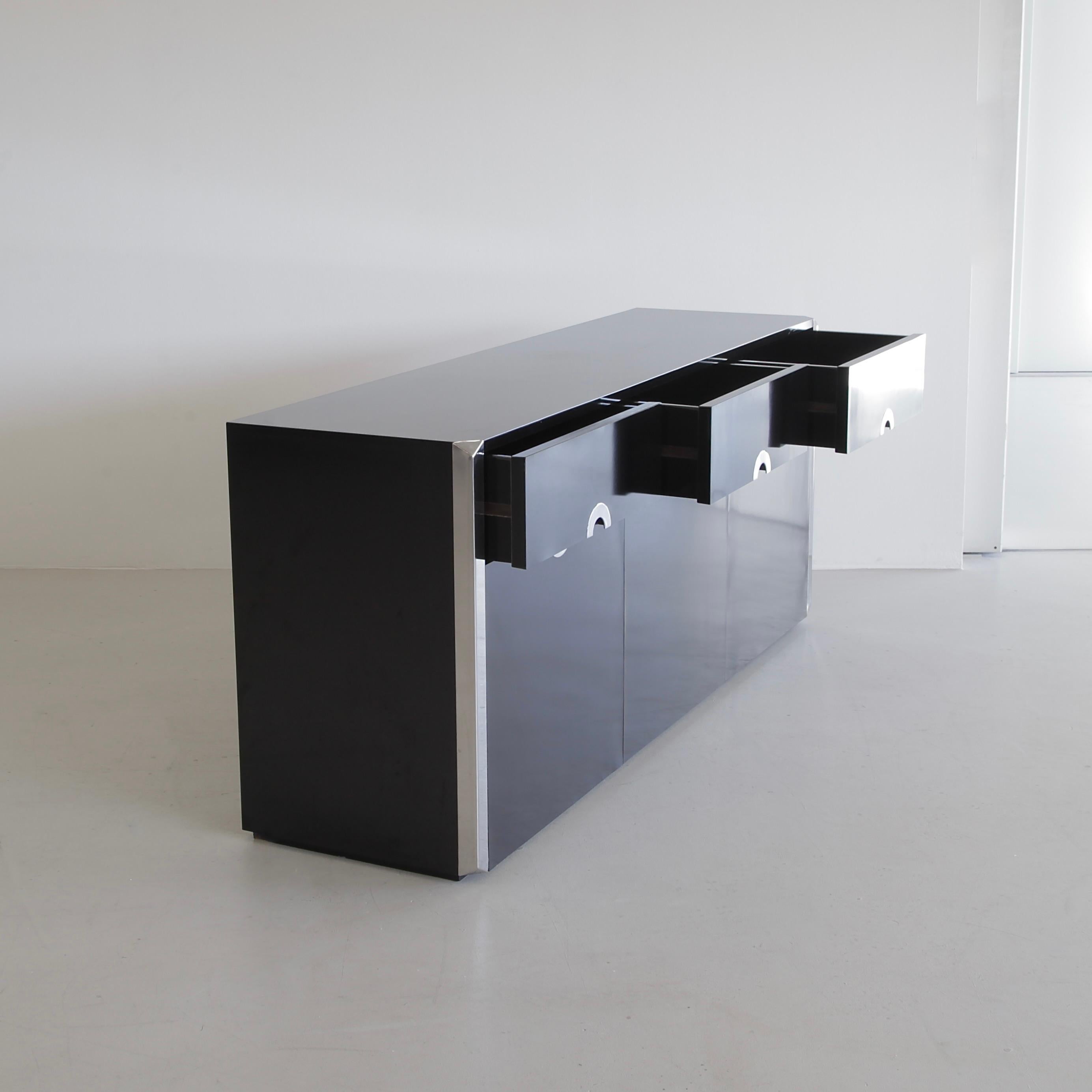 Schwarzes dreitüriges Sideboard, entworfen von Willy Rizzo. Italien, Mario Sabot, 1972. Anrichte mit schwarzem Laminat und Chromdetails, entworfen von Willy Rizzo und hergestellt von Mario Sabot.

Zwei Türen, eine mittlere Klapptür und drei