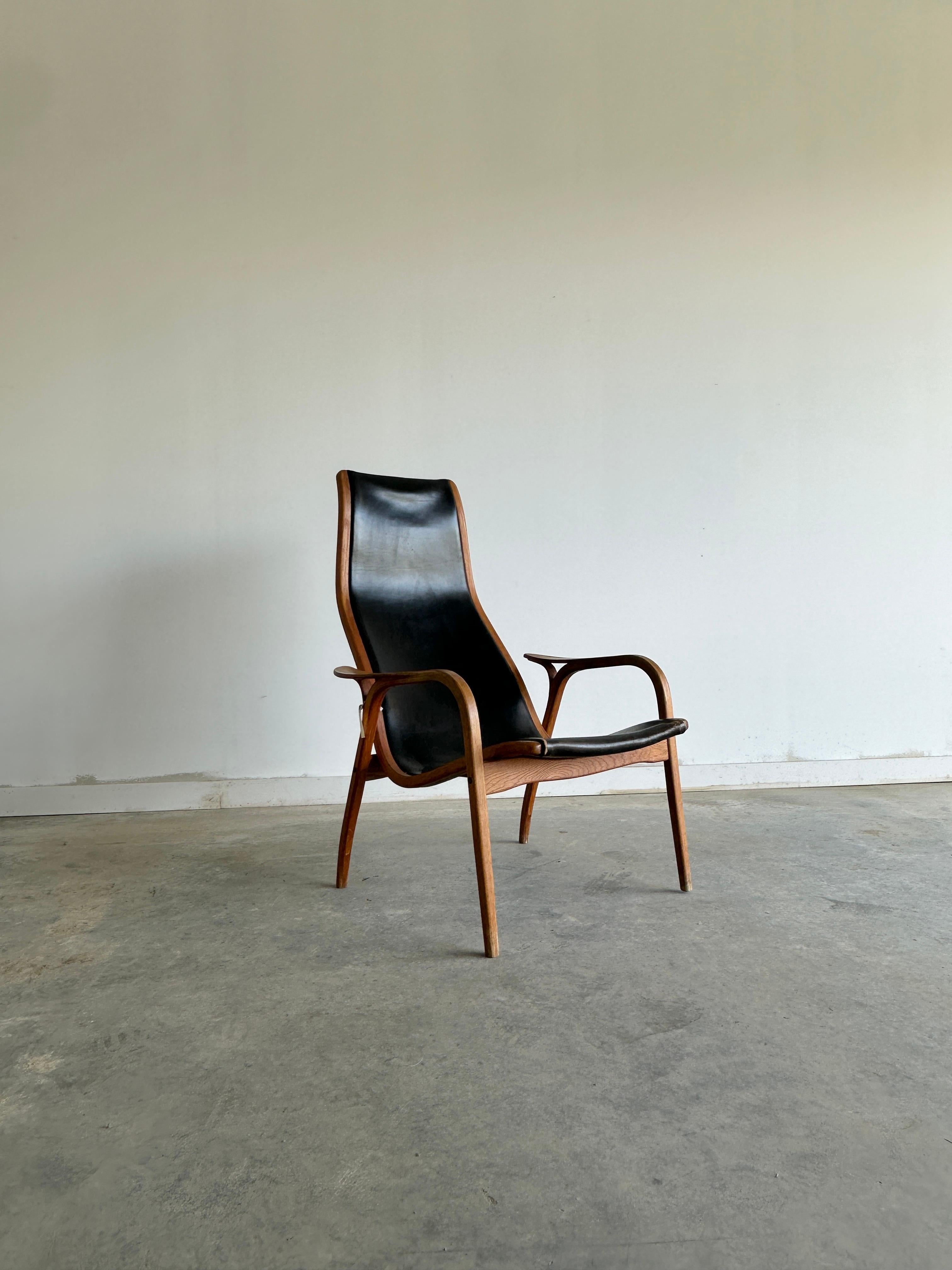 The Lamino chair by Yngve Ekström for Swedese is a classic piece of Scandinavian design that combines simplicity, comfort and elegance. The chair has a curved wooden frame that supports an original black leather seat and backrest. The Lamino chair