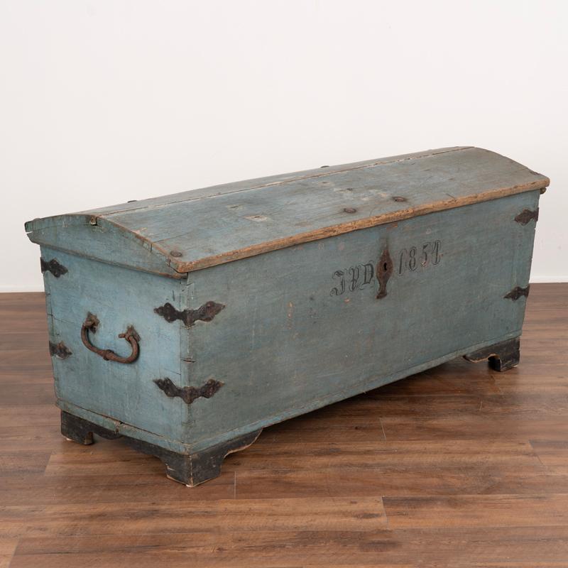This blue painted trunk is a great example of Swedish country craftsmanship. The large size, domed top, and hand-painted monogram and date all reflect its Swedish heritage. The wrought iron details include the heavy side handles, corners, and long
