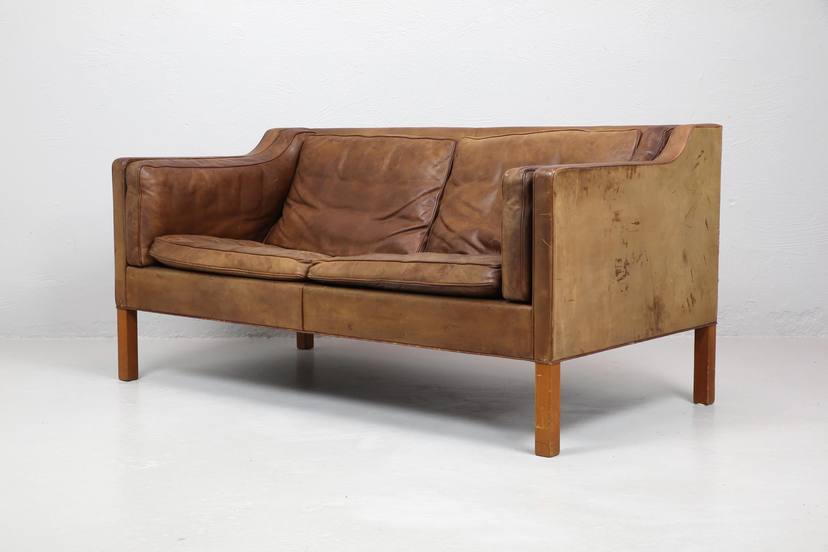 Original two-seat model 2212 sofa designed by Borge Mogensen in 1965 and made by Frederecia, Denmark. In original condition with a some wear, marks and patina to the leather. A pair are available.