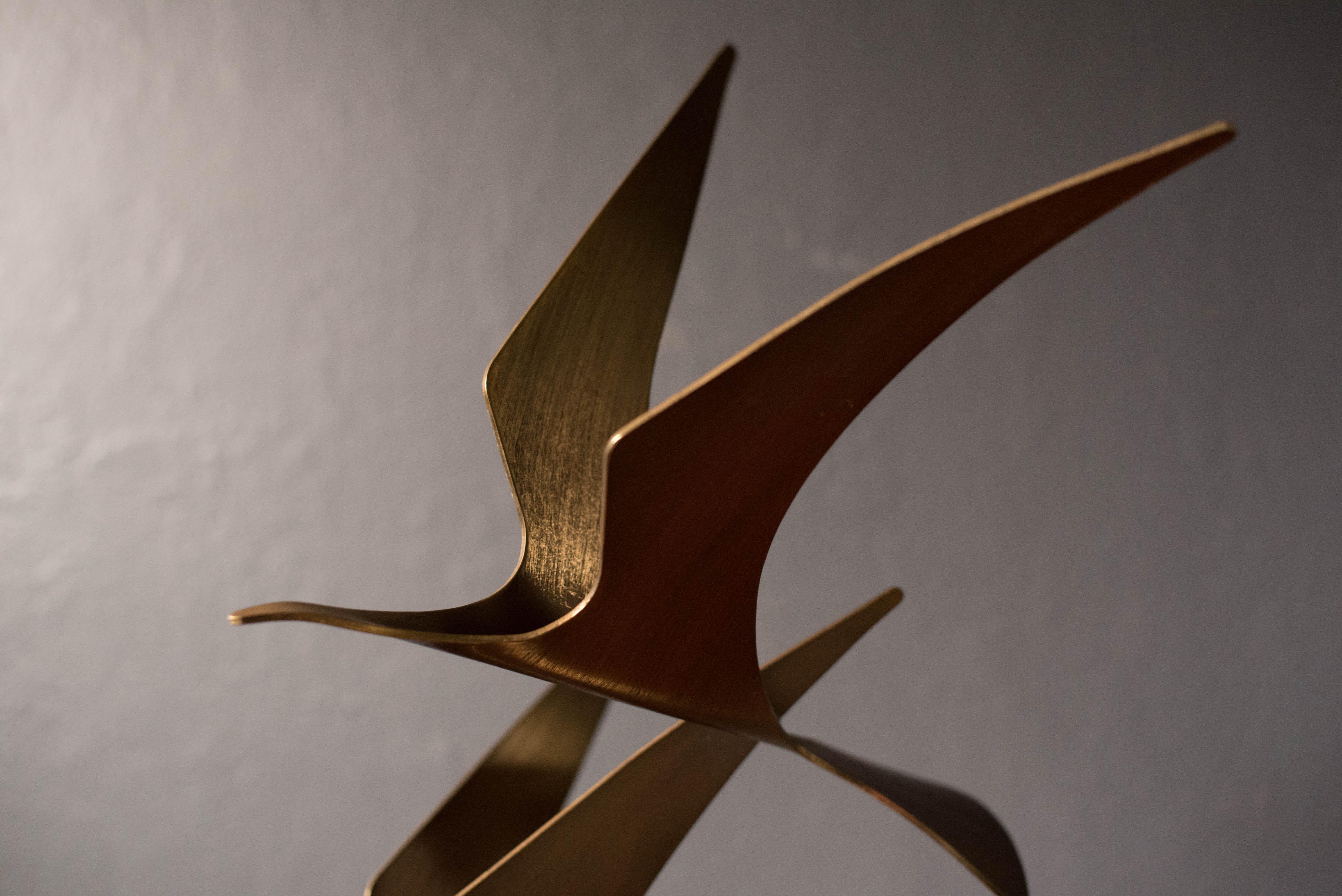 Abstract birds in flight sculpture by Curtis Jere, circa 1981. The bird sculptures are made of brass and sits on a heavy stone base.