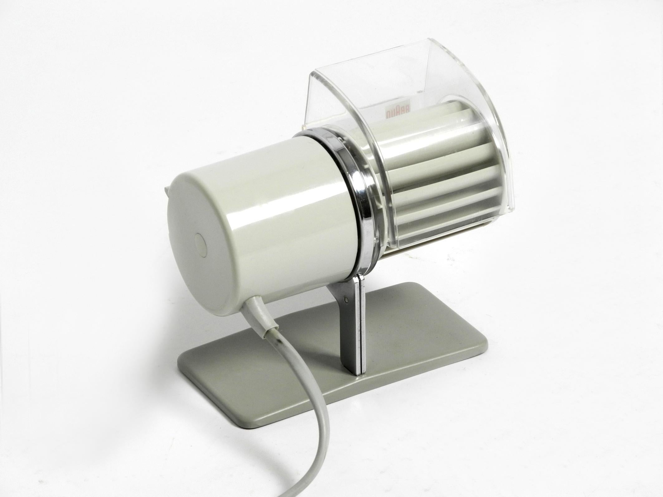 Ventilateur de table HL 1 original de Braun datant de 1961.
Design/One : Reinhold Weiss. Fabriqué en Allemagne de l'Ouest
La sortie d'air peut être tournée en continu. 2 niveaux. Le montage mural est également possible, grâce aux crochets d'origine