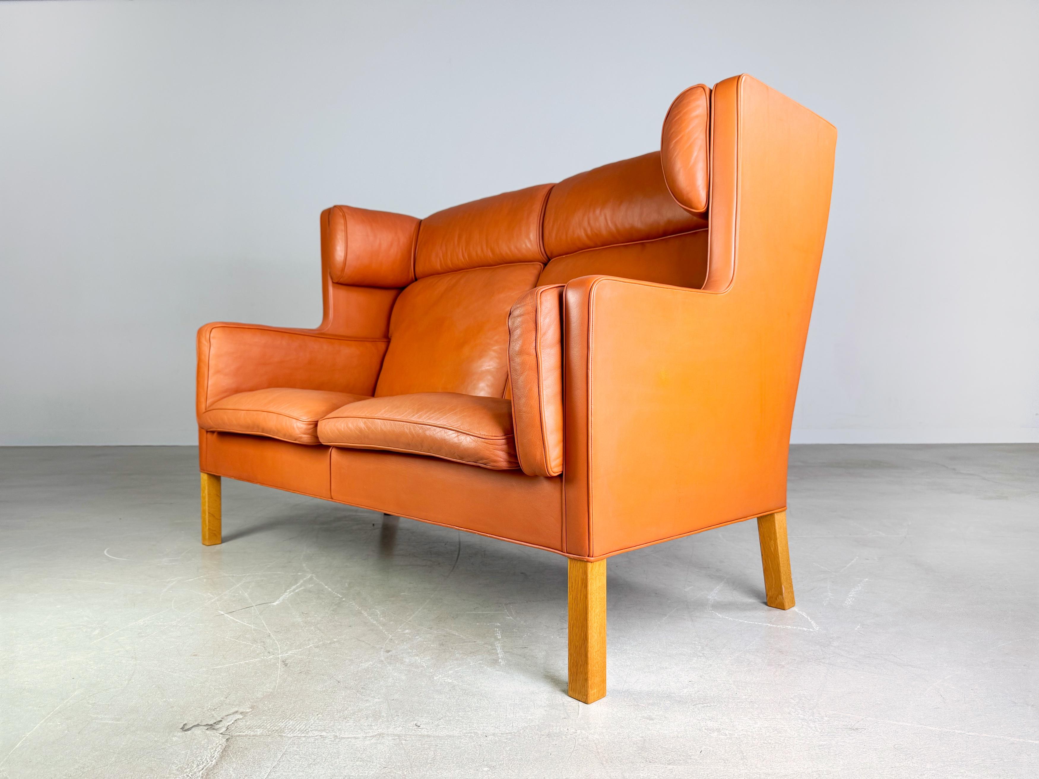 Te ofrecemos un maravilloso Sofá Zweisitzer Coupé 2193 en color coñac de Fredericia Stolefabrik para su compra. El diseño procede de Borge Mogensen, uno de los diseñadores de productos más conocidos de los últimos siglos. La madera y los muebles se