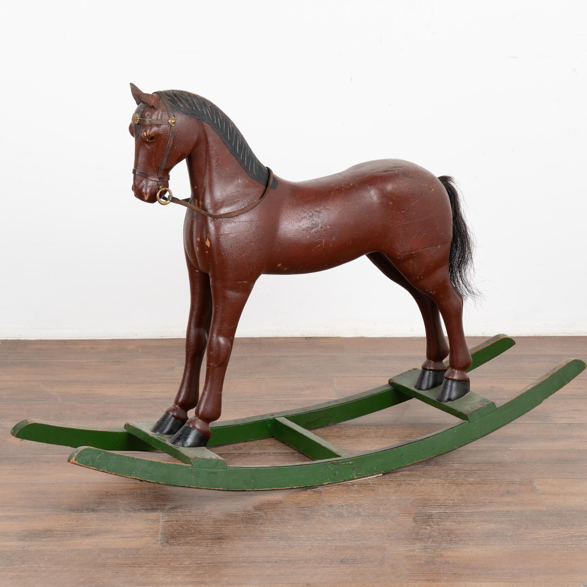 It is the worn look that creates the wonderful appeal of this original painted and carved rocking horse from Sweden.
The brown/brick paint has been distressed (some missing, see photo of direct front). Note also the cracked leather ears, carved and