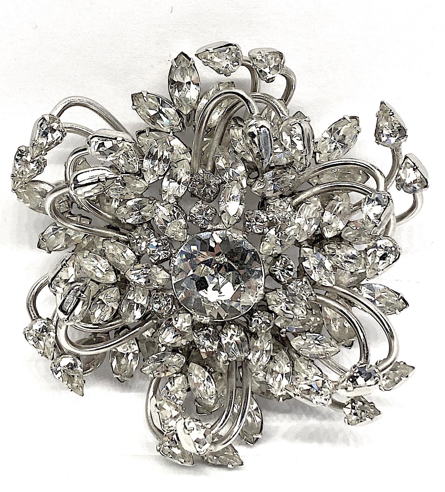 A beautifully hand made and constructed large three dimensional flower brooch from the 1950s by company Original by Robert. The large central 14 mm rhinestone is surrounded by smaller round and marquise stones. This in turn is mounted upon six petal