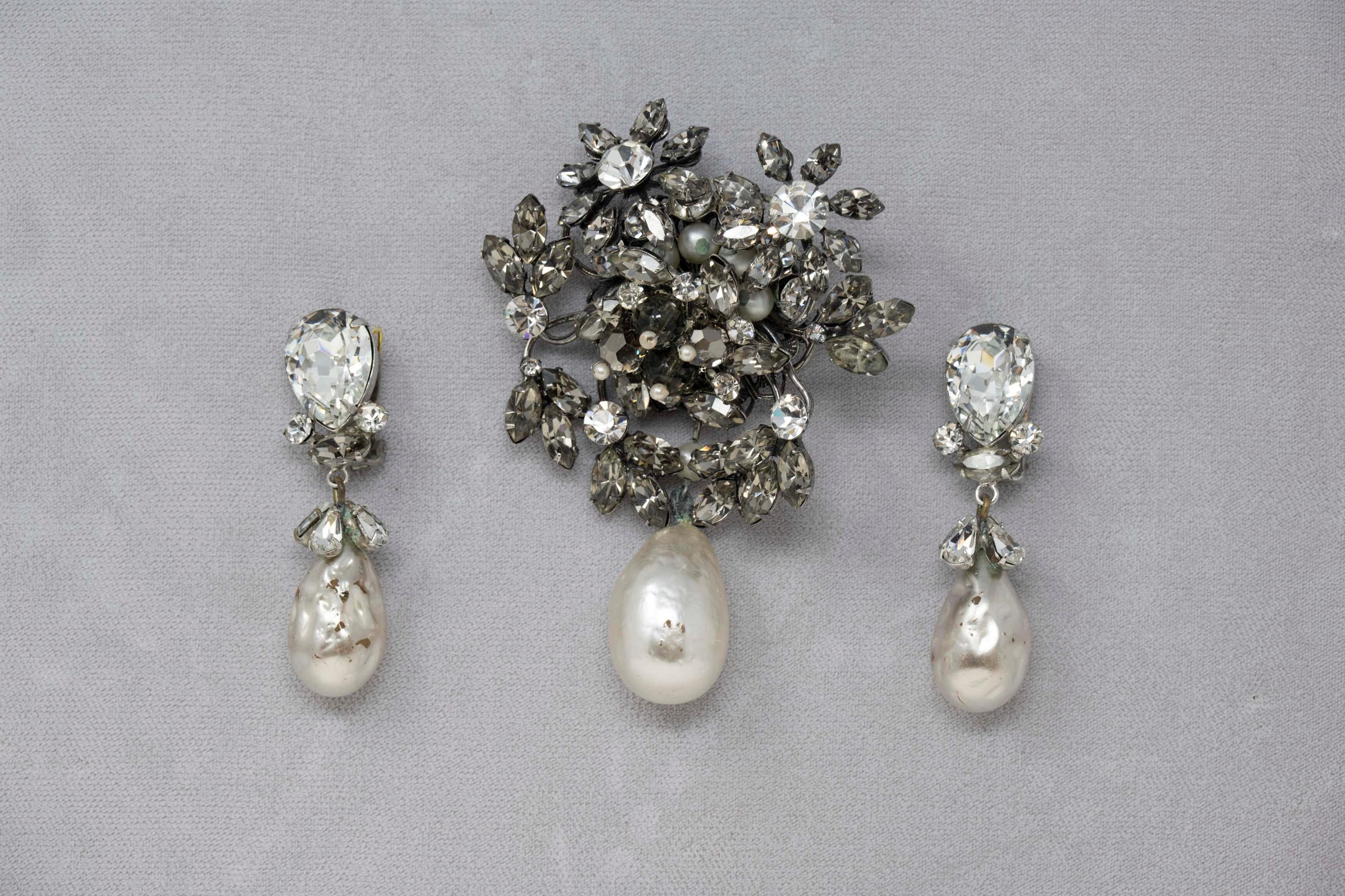 Original by Robert faux pearls and rhinestones brooch & clip-on earrings. Mid 20th century, 1960, crystal pearl and measures 2 1/2 inches in diameter, 2 1/4 inches long. Wear consistent with age, scratches on the pearls.
