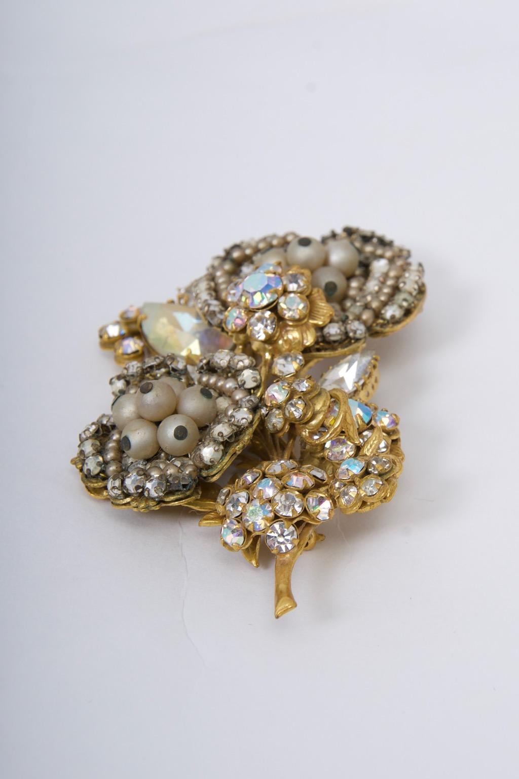 Large brooch by Robert featuring both clear and aurora borealis crystals along with pearls composed in an intricate flower design. Similar to the work of Miriam Haskell, Robert's designs of the 1950s and '60s employed wires to attach the elements to