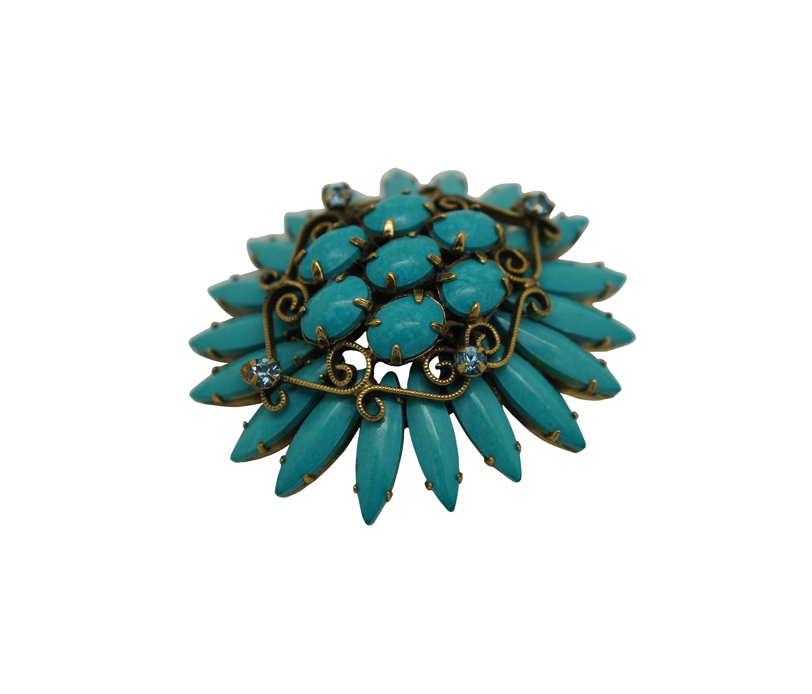 Mid 20th century Original by Robert pin / brooch featuring a Southwest inspired design of turquoise stones arranged in the shape of a flower, accented with scrolling brass and aqua rhinestones.

