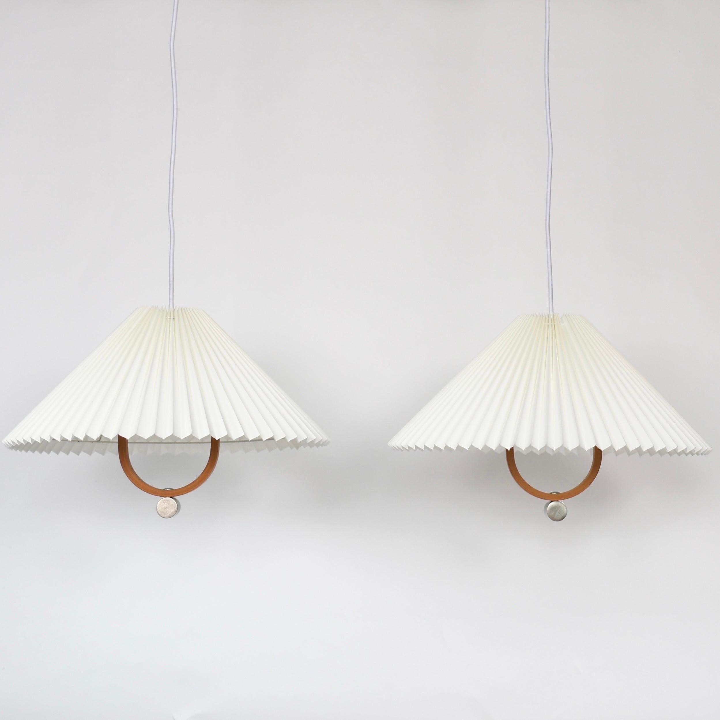 Lampade a sospensione originali Caprani realizzate da Mads Caprani negli anni '70. Un set raro per un posto bellissimo. 

* Set (2) di luci a sospensione in legno di faggio impiallacciato con paralumi plissettati di colore bianco sporco.
* Designer: