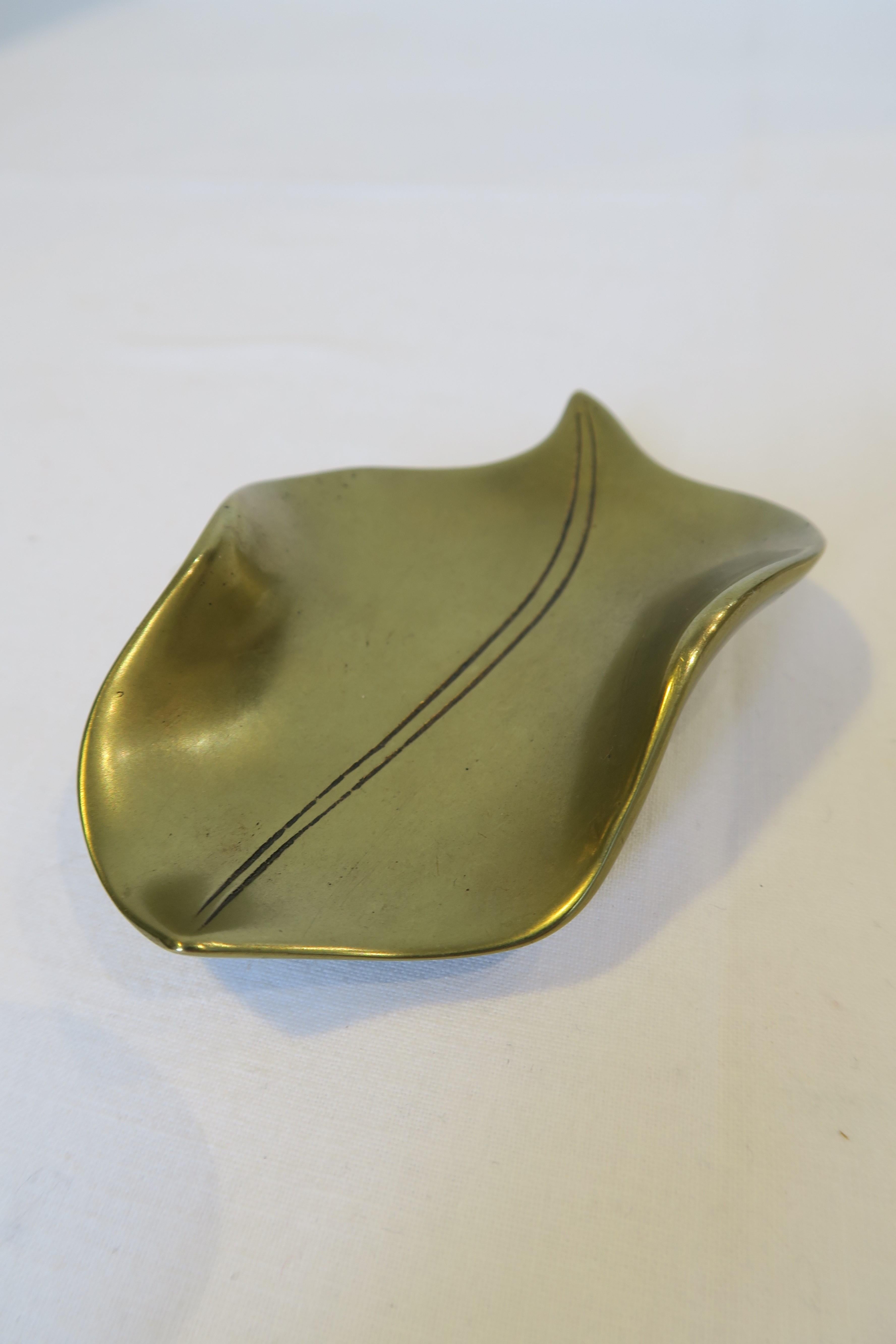 For sale is a beautiful decorative dish in the shape of a leaf. It was hand-crafted from brass and designed by the renowned workshops of Carl Auböck in Austria. It is a perfect example of the typical form-follows-function-style of the 50s and German