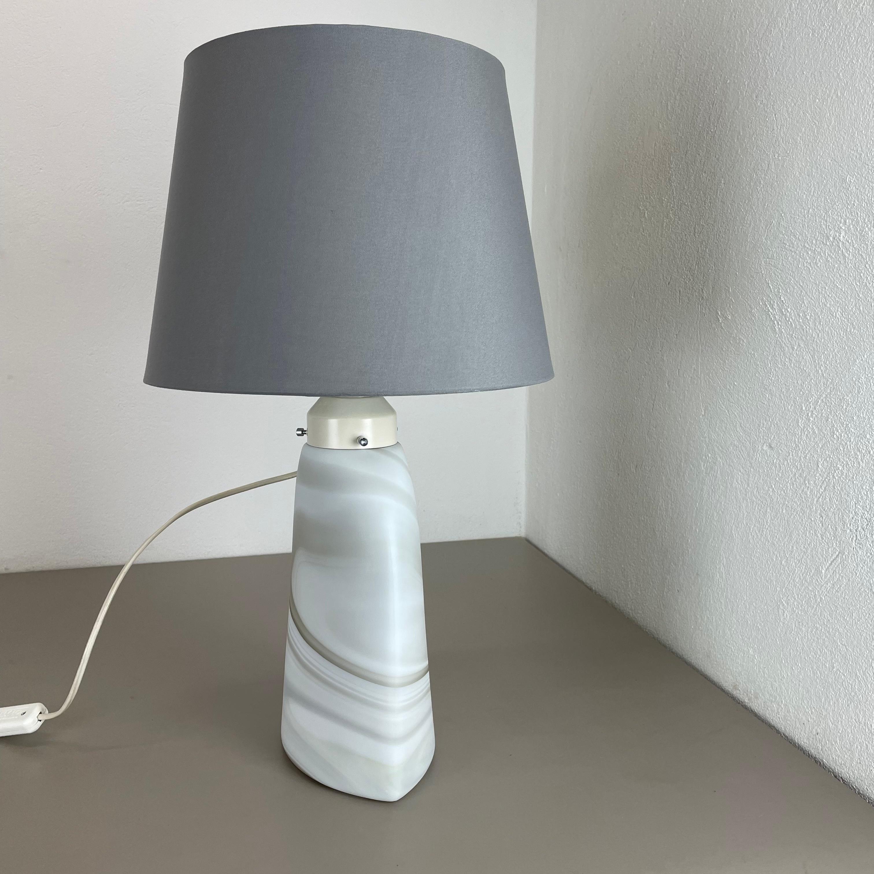 Article:

Glass table lamp, cararra series.


Producer:

Peill & Putzler, Germany



Age:

1970s



 

Original table light made in the 1970s by Peil & Putzler in Germany. The light base element is made of one piece of glass. it