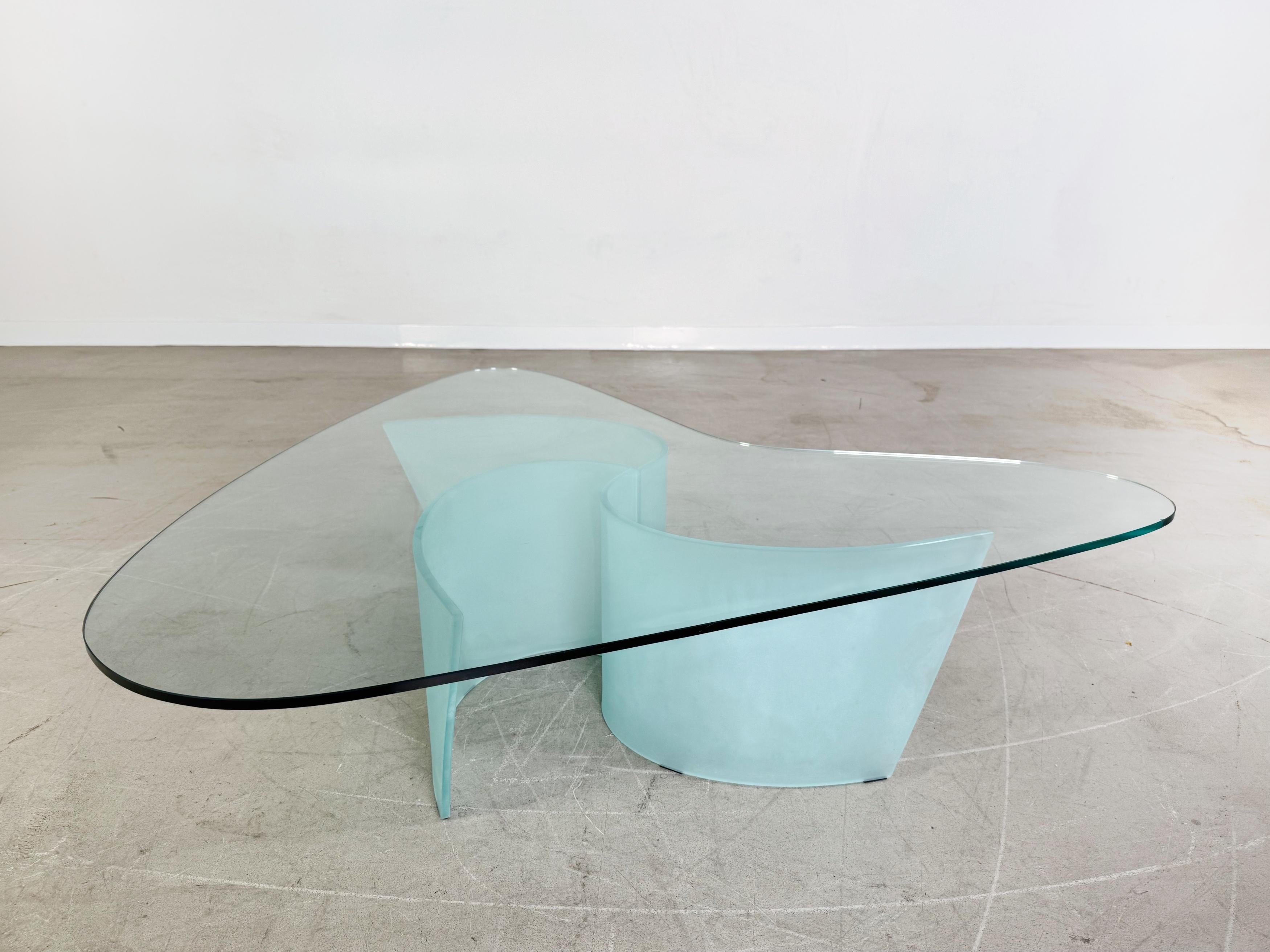 Wir bieten einen wunderschönen Glas Couchtisch von Cattelan Italia zum Verkauf an. Der Tisch verfügt über drei stabile Füße aus Milchglas, die unabhängig voneinander variabel gestellt werden können um die Tischplatte zu tragen. An einer Seite der