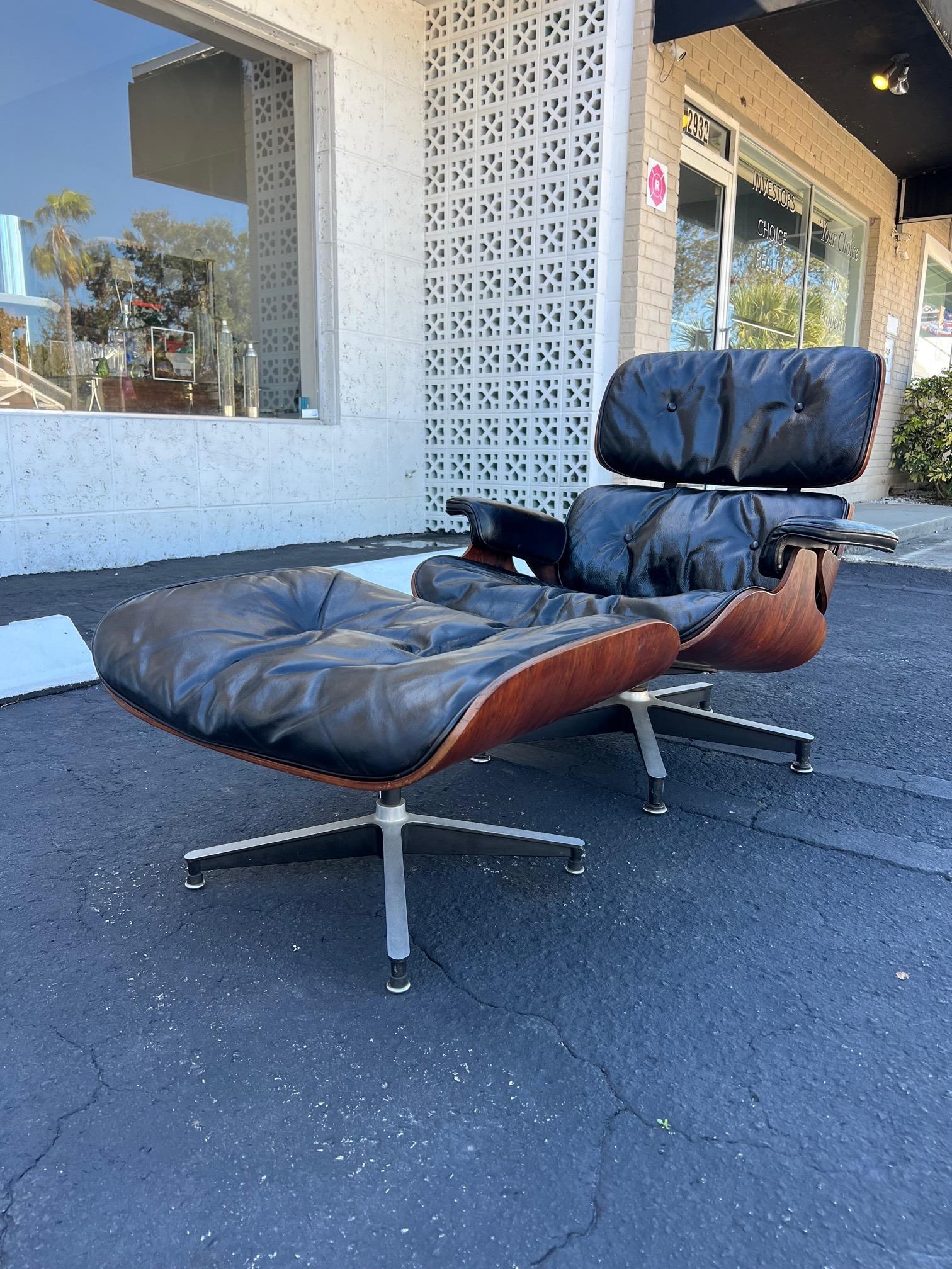 Première édition classique et originale - vers 1950 - de la chaise longue et de l'ottoman de Charles Eames pour Herman Miller, connus sous les numéros 670 et 671. Cuir noir et bois de rose, avec une rare étiquette d'origine. Configuration à trois