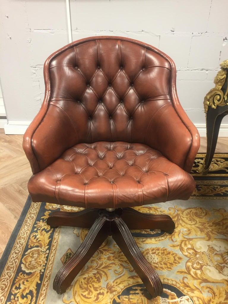Vintage tufted brown Leather English Chesterfield style barrel back desk chair. Item features rolled arms, nailhead trim, deep button tufts, and a solid wood base on rolling casters. Leather has achieved a beautiful patina. Believed to be a vintage