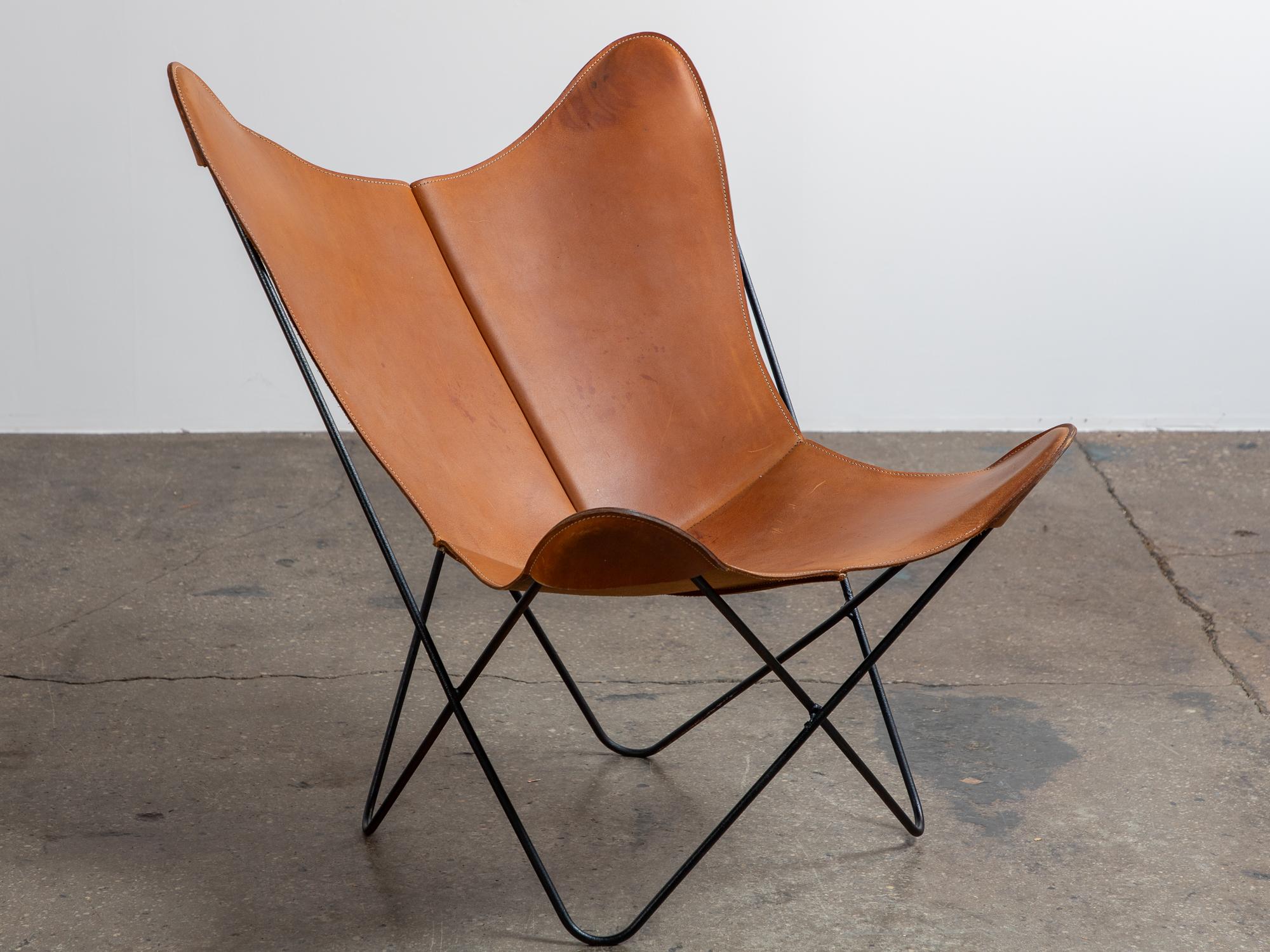 Vintage Butterfly Chair with tan leather sling, designed by Antonio Bonet, Juan Kurchan & Jorge Ferrari-Hardoy, issued by Knoll. An iconic mid-century design with a relaxed and rugged vibe. The chair's distinctive look comes from a leather sling