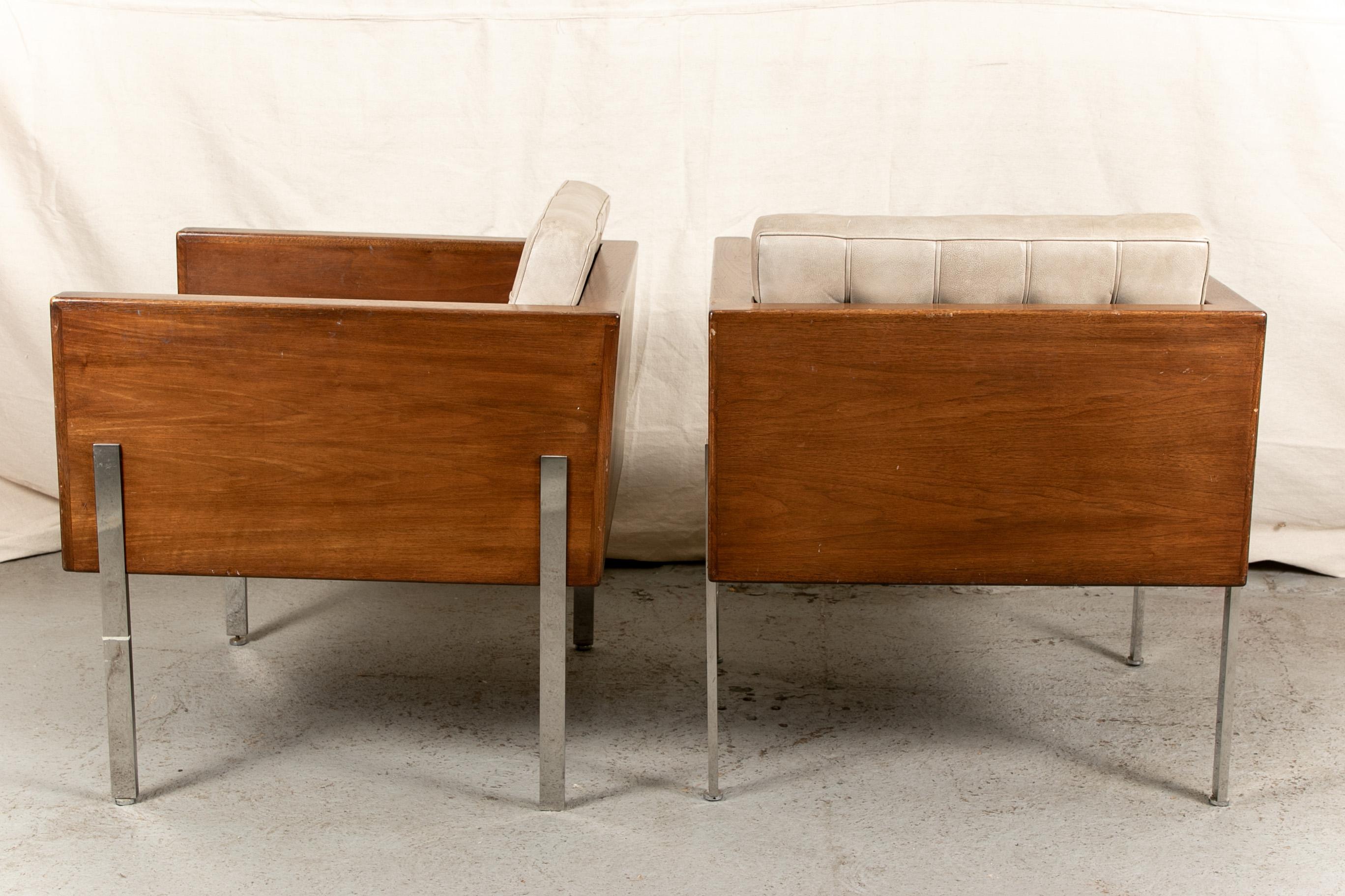 A pair of all original condition Cube chairs by Harvey Probber from his iconic Architectural Series. Square walnut frames with black leather backs with notches at the top. Flat chrome legs attached front and back on the sides of the frames. With