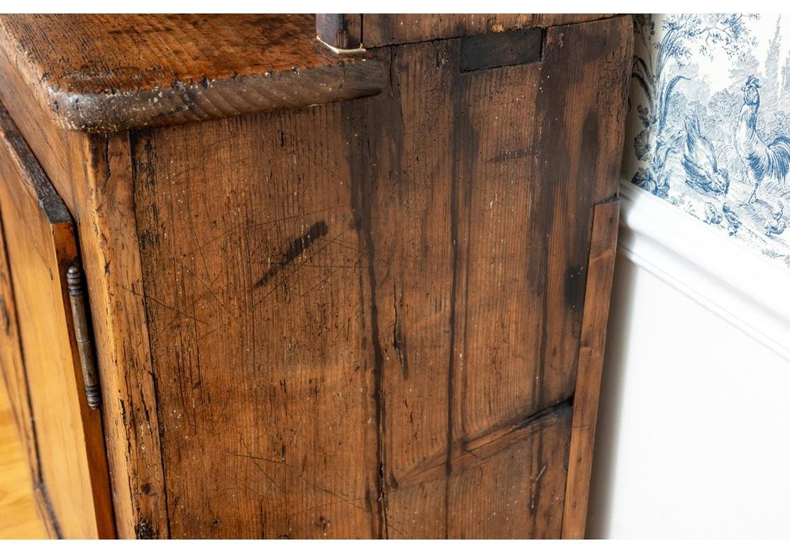 A time-softened American pine step back Hutch with a desirable Chestnut and fine soft hand. With two upper display shelves with plate stops and bars, a single center utensil drawer and the bottom drawers opening to a centrally fixed inner shelf.