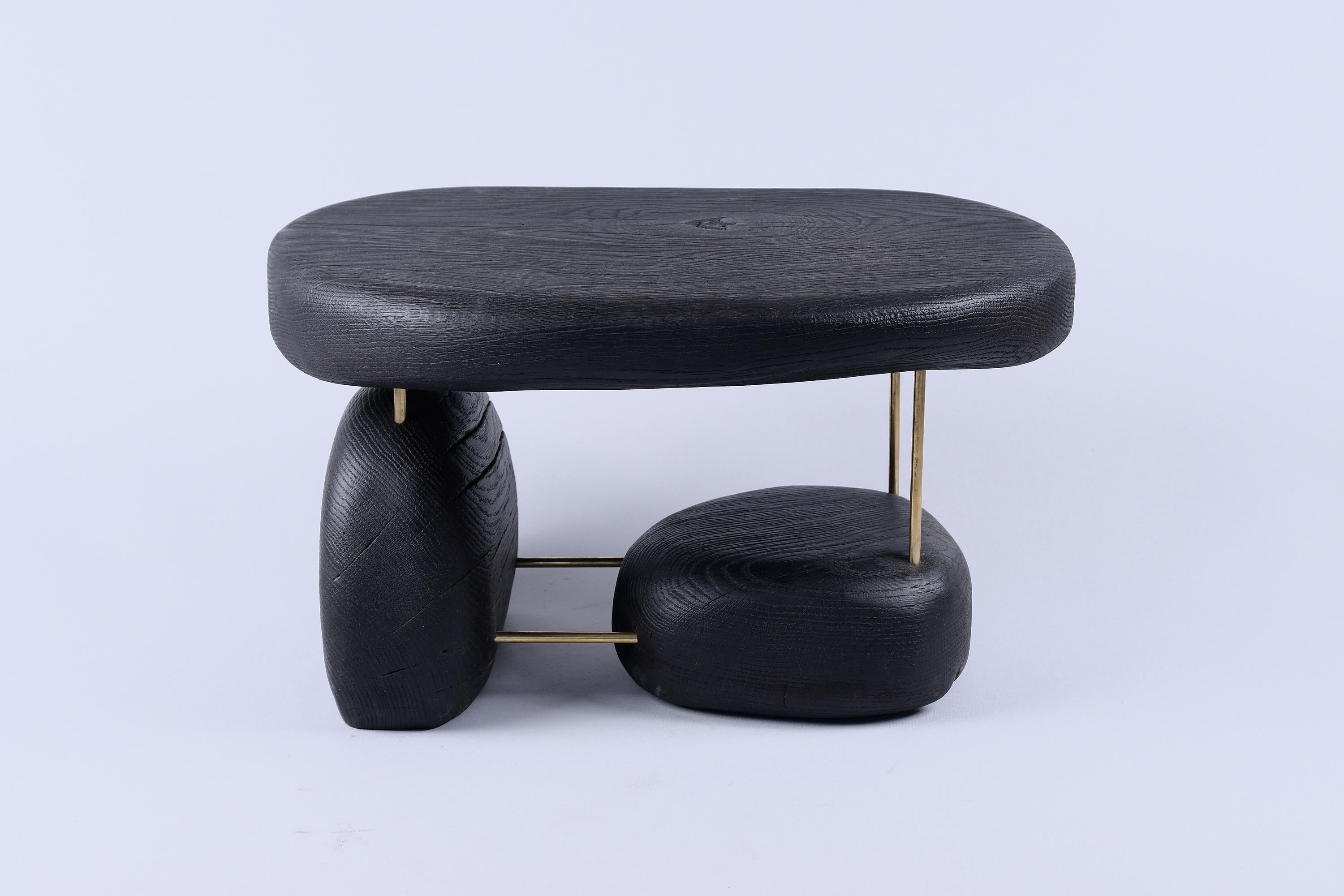 Pièce unique en bois multifonctionnelle pouvant servir de table d'appoint, de tabouret ou simplement d'objet décoratif. Il est fabriqué à partir d'une combinaison de chêne brûlé de haute qualité et de laiton, et protégé par des huiles de la plus