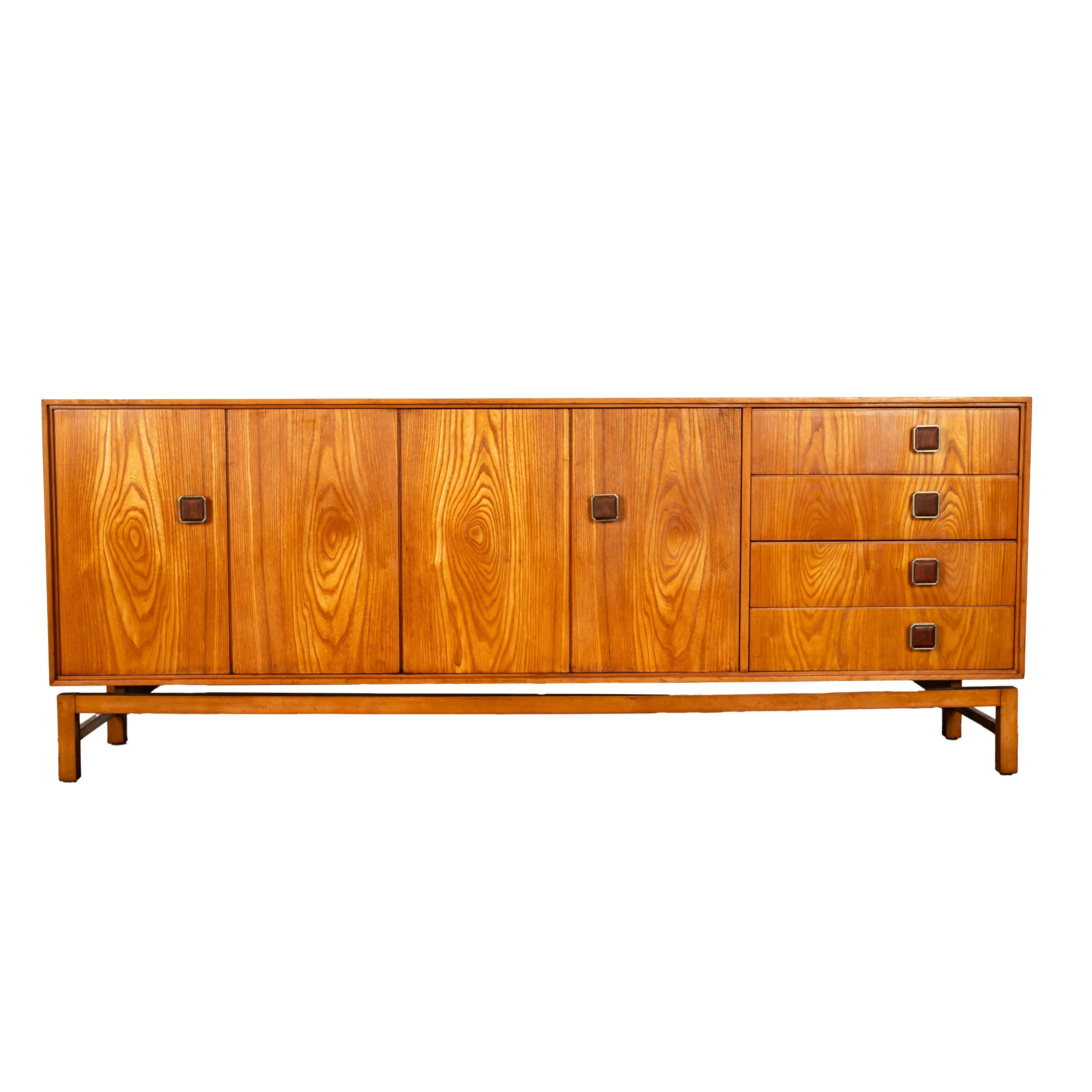 A good Danish Mid-Century Modern teak credenza, 1960s.
The credenza having a pair of 'concertina' doors that open to reveal a single shelf, on the right side of the credenza is a bank of four drawers. The credenza is raised on a 'floating' base, the