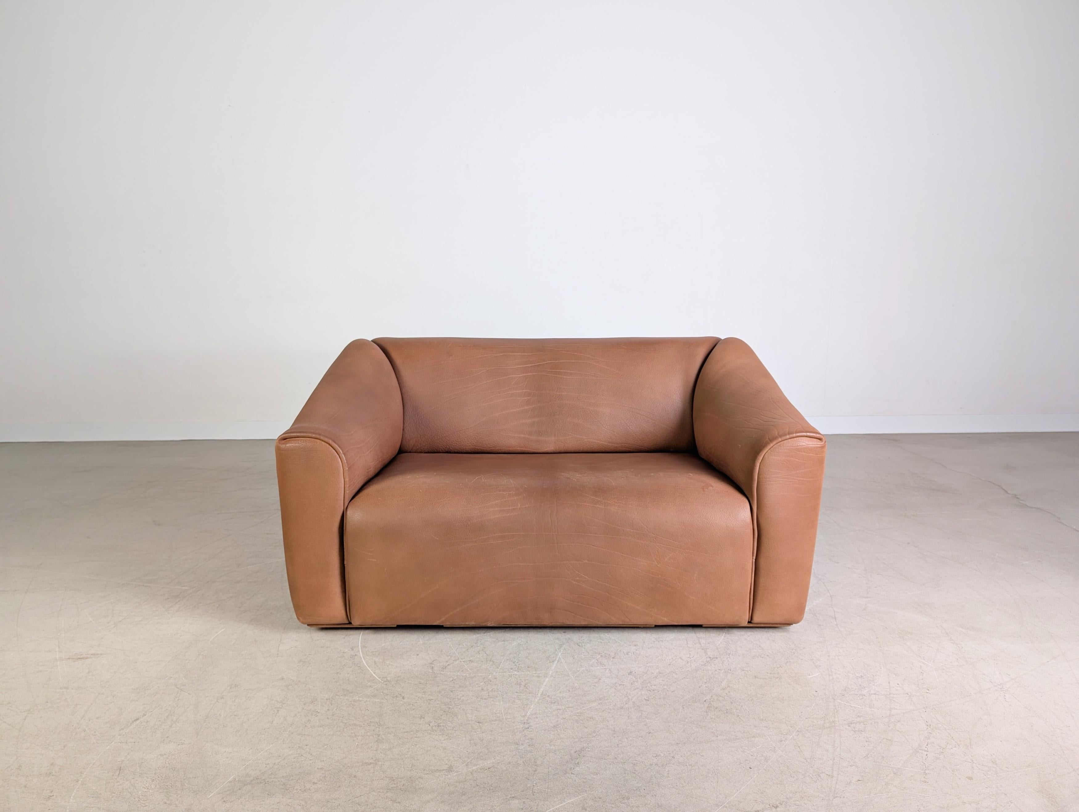 Wir bieten ein wunderschönes und nahezu neuwertiges de Sede DS 47 Zweisitzer Sofa aus dem Jahr 1983 zum Verkauf an. Das Möbel wurde aus robustem Dickleder gefertigt und lässt sich leicht ausziehen, womit eine niedrigere Sitzposition eingenommen