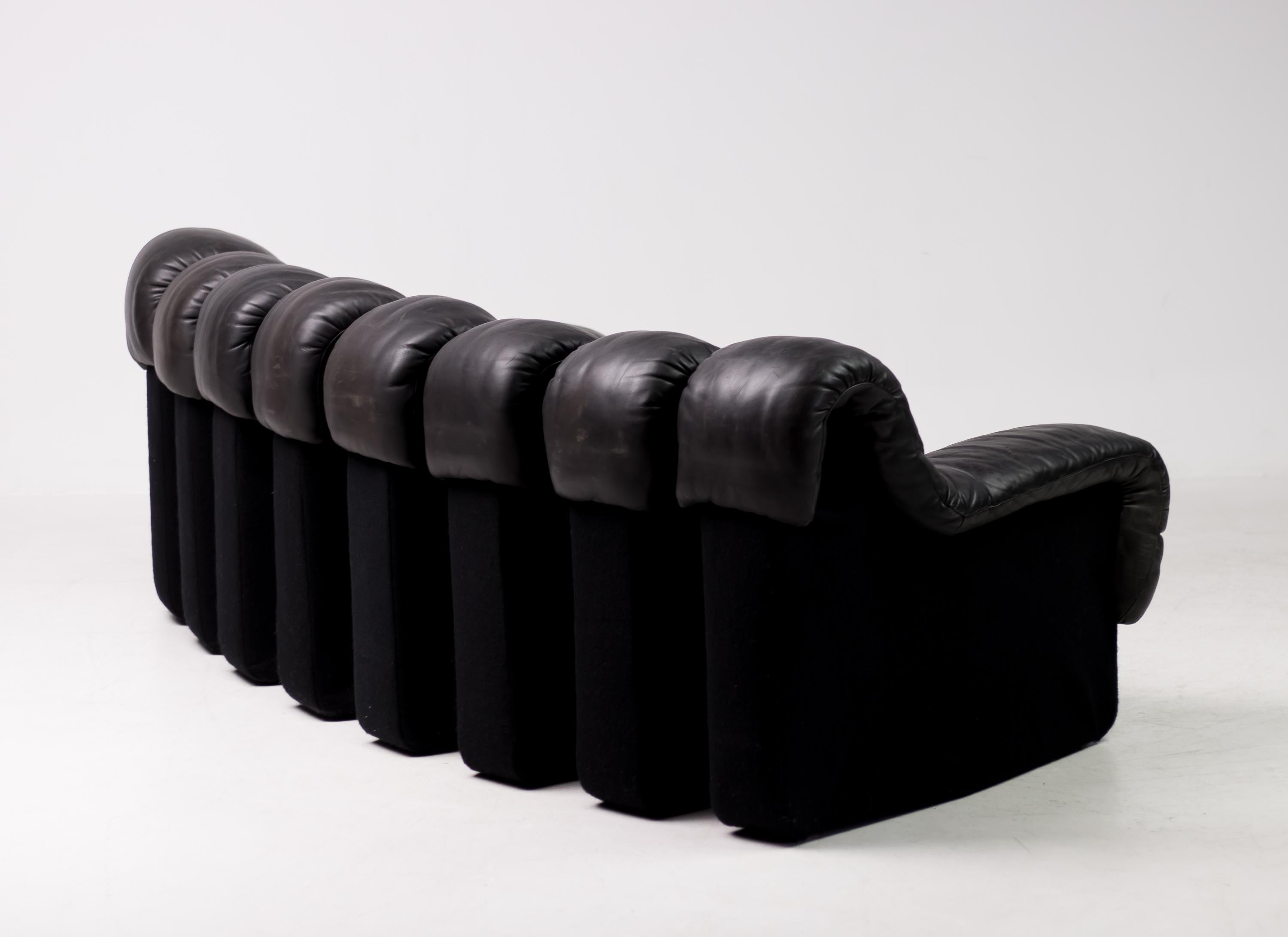 Iconic vintage DS 600 nonstop sectional leather sofa designed by Heinz Ulrich, Ueli bergère and Elenora Peduzzi-Riva and manufactured by De Sede. The sofa sections consist of original black leather and black felt bases.
The distressed leather shows