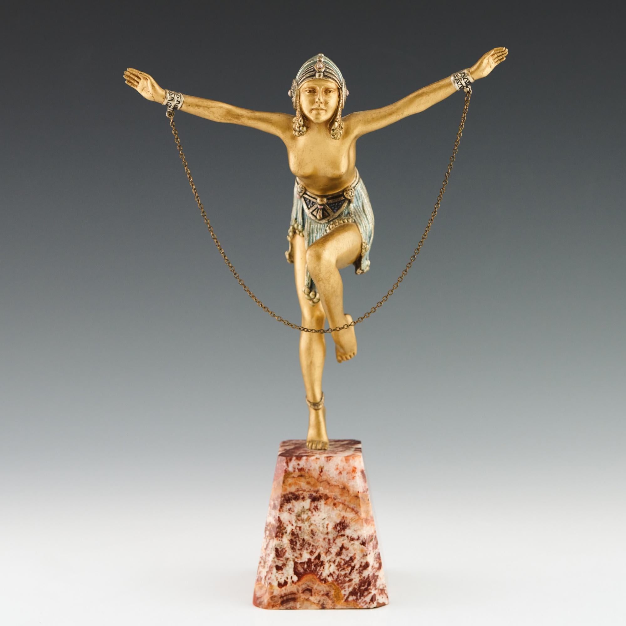 'A Dancer' an Art Deco cold painted gilt bronze figure by Demetre Chiparus (1886-1947). An athletic dancer dressed in scantily clad theatrical costume with arms outstretched in a stylised pose with chain connected to both arms. Excellent hand