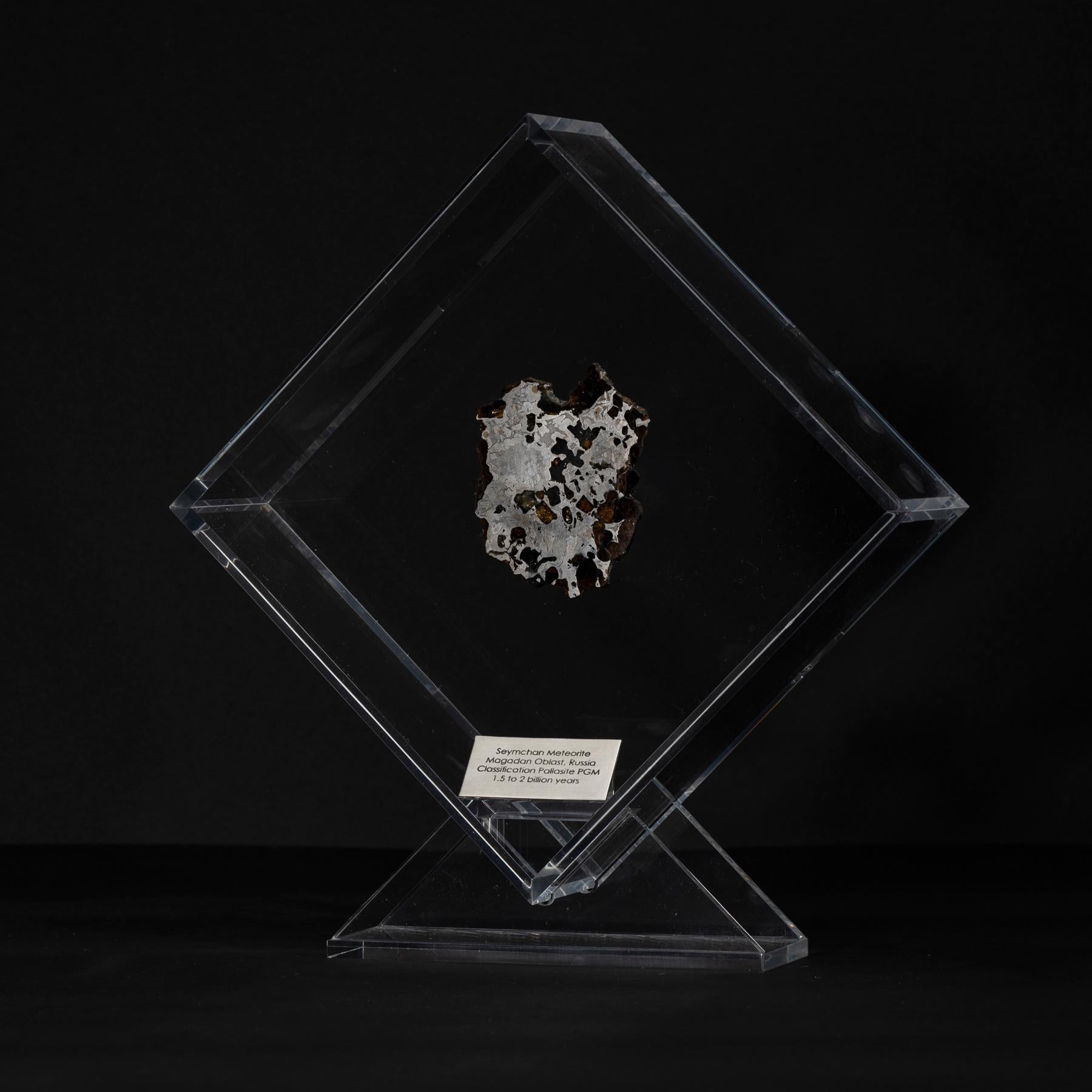 Design/One original dans un présentoir en acrylique avec un aimant donnant l'impression que la météorite flotte comme elle l'a fait dans l'espace pendant des années avant sa dernière visite sur Terre. 
Seymchan avec météorite à olivine 
Origine :