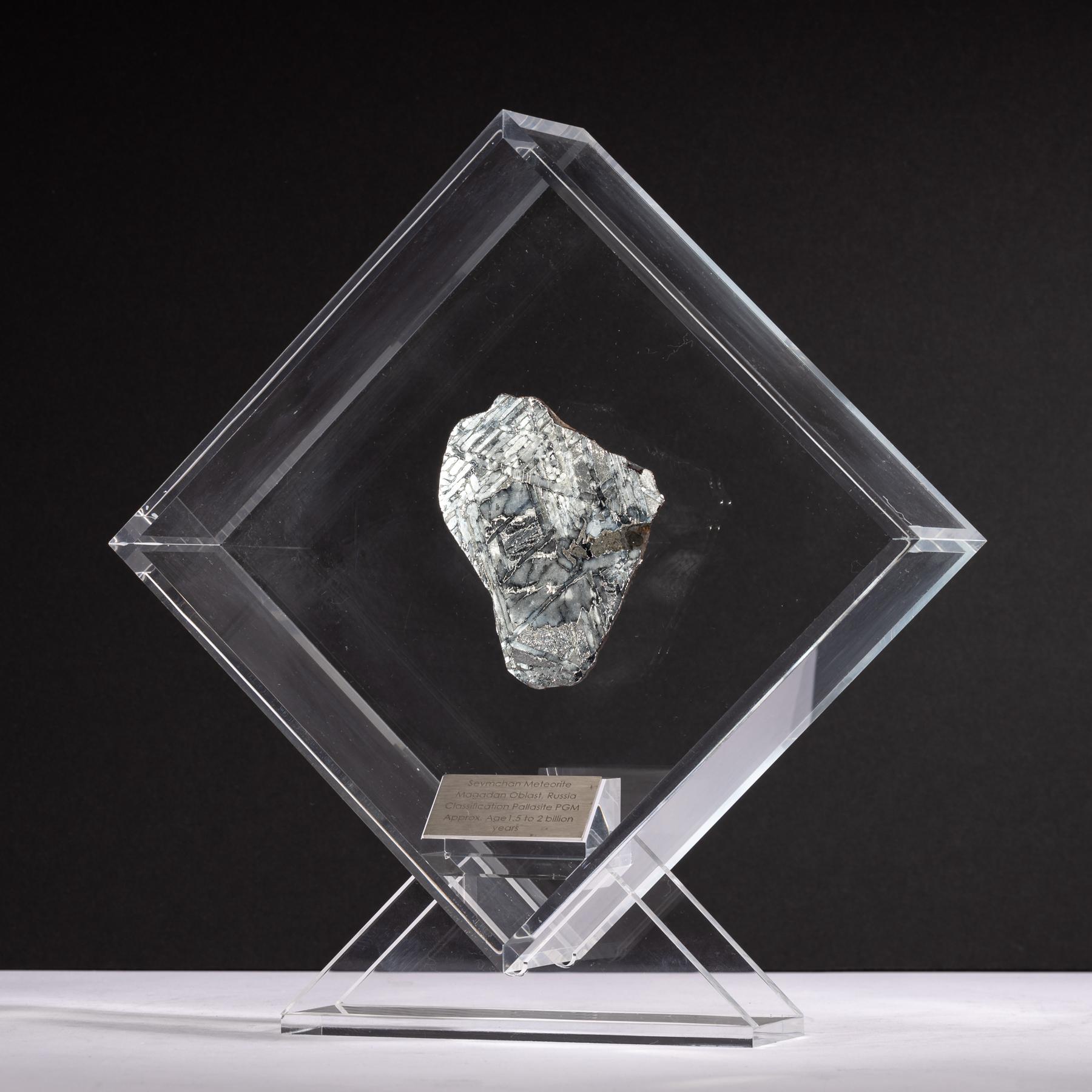 Originelles Design in einem Acryl-Display mit einem Magneten, der den Meteoriten so aussehen lässt, als würde er noch Jahre vor seinem letzten Besuch auf der Erde im Weltraum schweben. 
Seymchan mit Olivin-Meteorit 
Herkunft: Magadan Oblast,