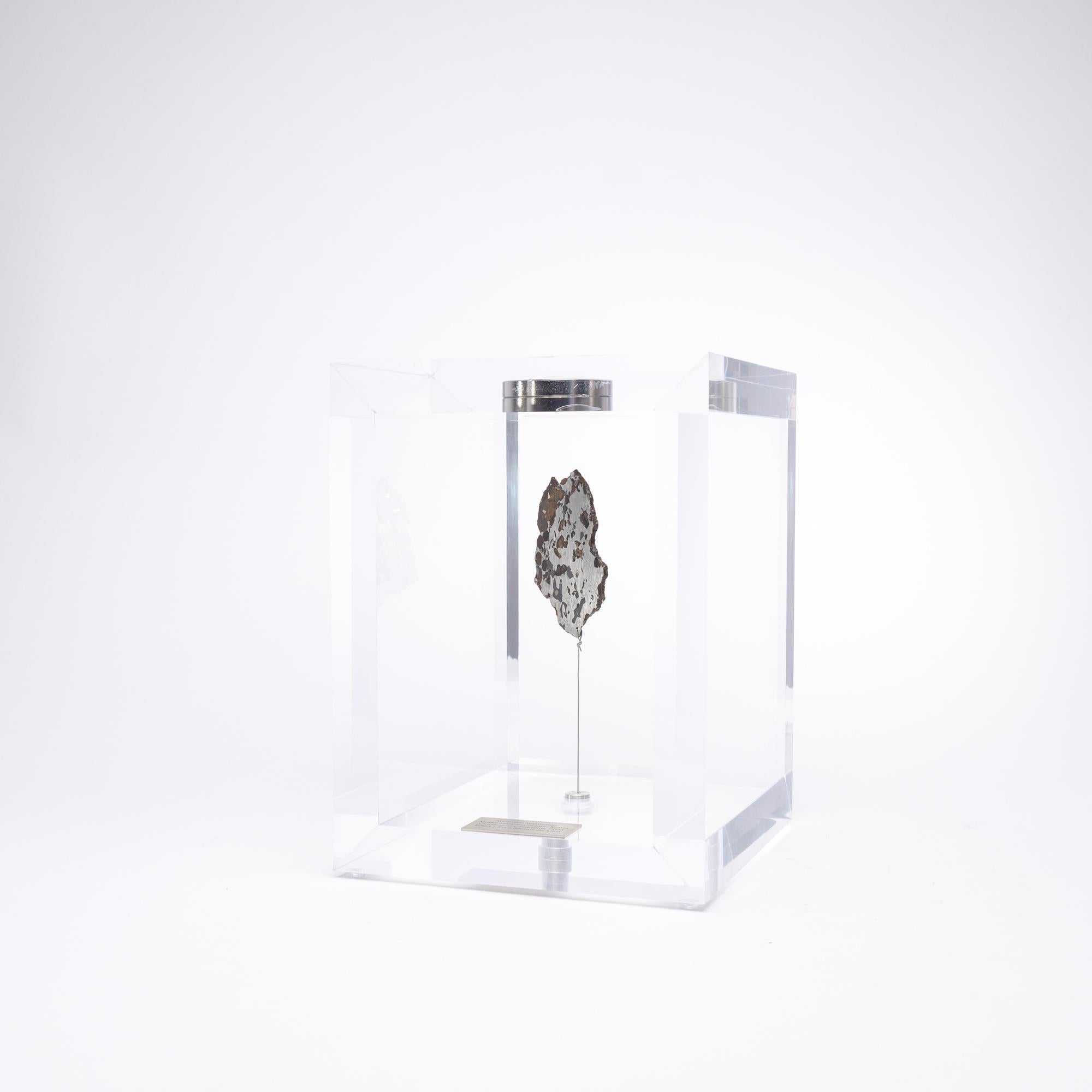 The “Space Box” was designed by Ernesto Duran, as a creative way to enhance the uniqueness of meteorites and could also be use as a decorative piece. Its an acrylic box with a magnet on top and a steel string pulling the meteorite straight