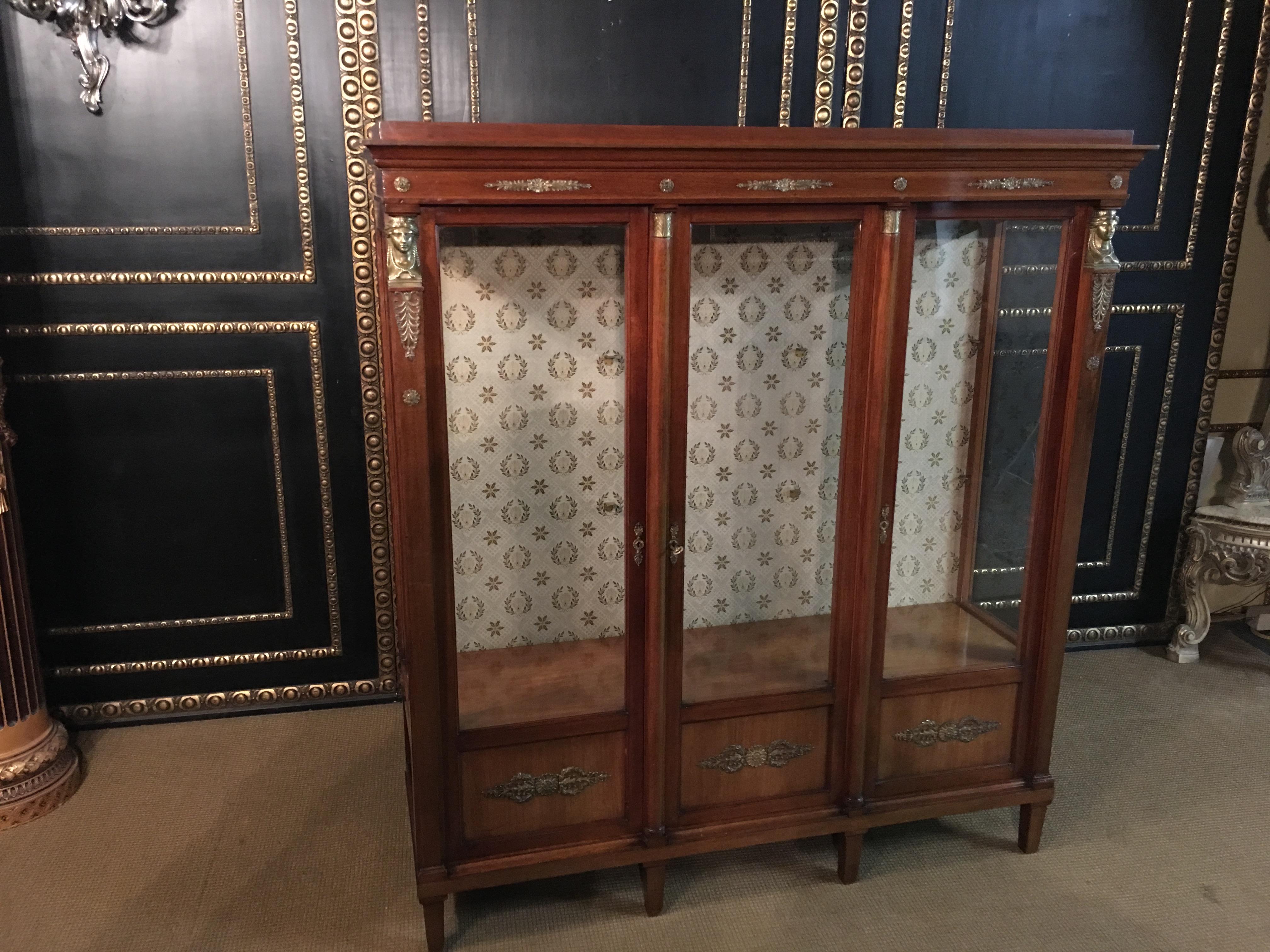Empire Biblithek, circa 1860s-1880s from an Empire room
mahogany with beautiful empire figures, cast bronze.
Very rare to get today.

3 glass doors, interior with glass shelves, back cover covered with fabric.

Very good historical