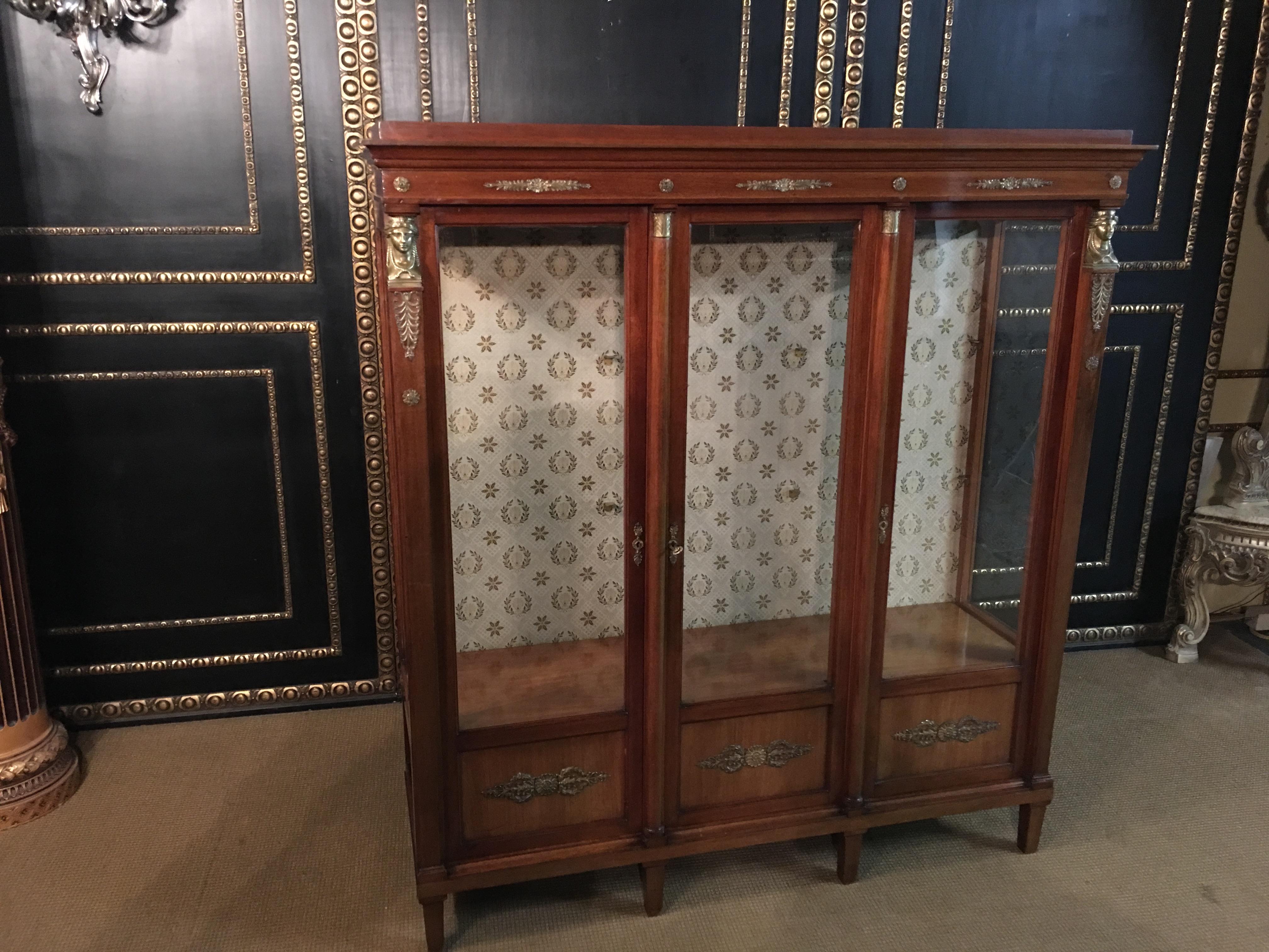 Empire Biblithek, circa 1860s-1880s from an Empire room
Mahogany with beautiful empire figures, cast bronze.
Very rare to get today.

3 glass doors, interior with glass shelves, back cover covered with fabric.

Very good historical