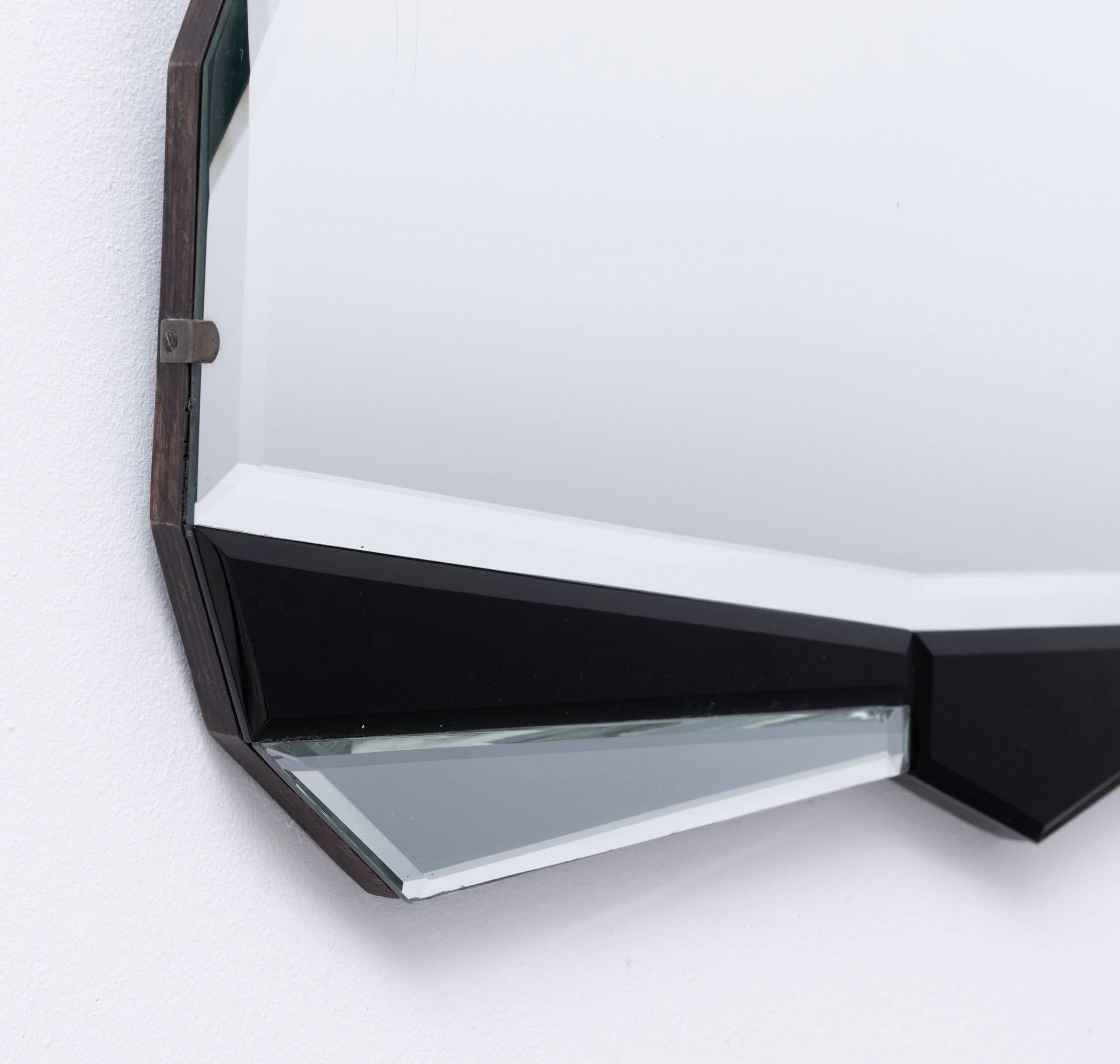 Good English Art Deco geometric fan shaped wall mirror with bevelled edging. Flanked with geometric black mirrored glass. Circa 1930.

The mirror is in very good condition showing some light foxing around the edge. There are three scratch marks