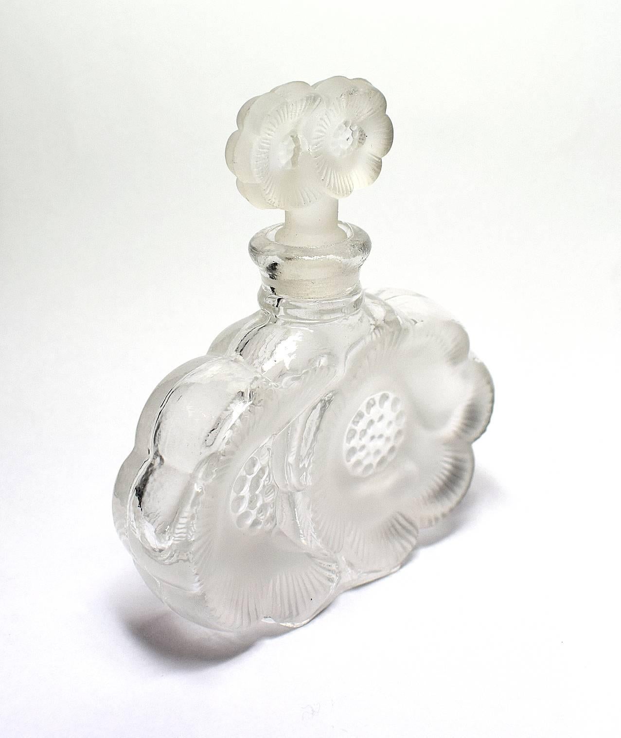A beautiful clear and frosted glass 1930s scent bottle which has a wonderful embossed floral shape. Overall condition is excellent, very minor signs of age with no damage anywhere. These bottles look great with perfume in or with colored water in