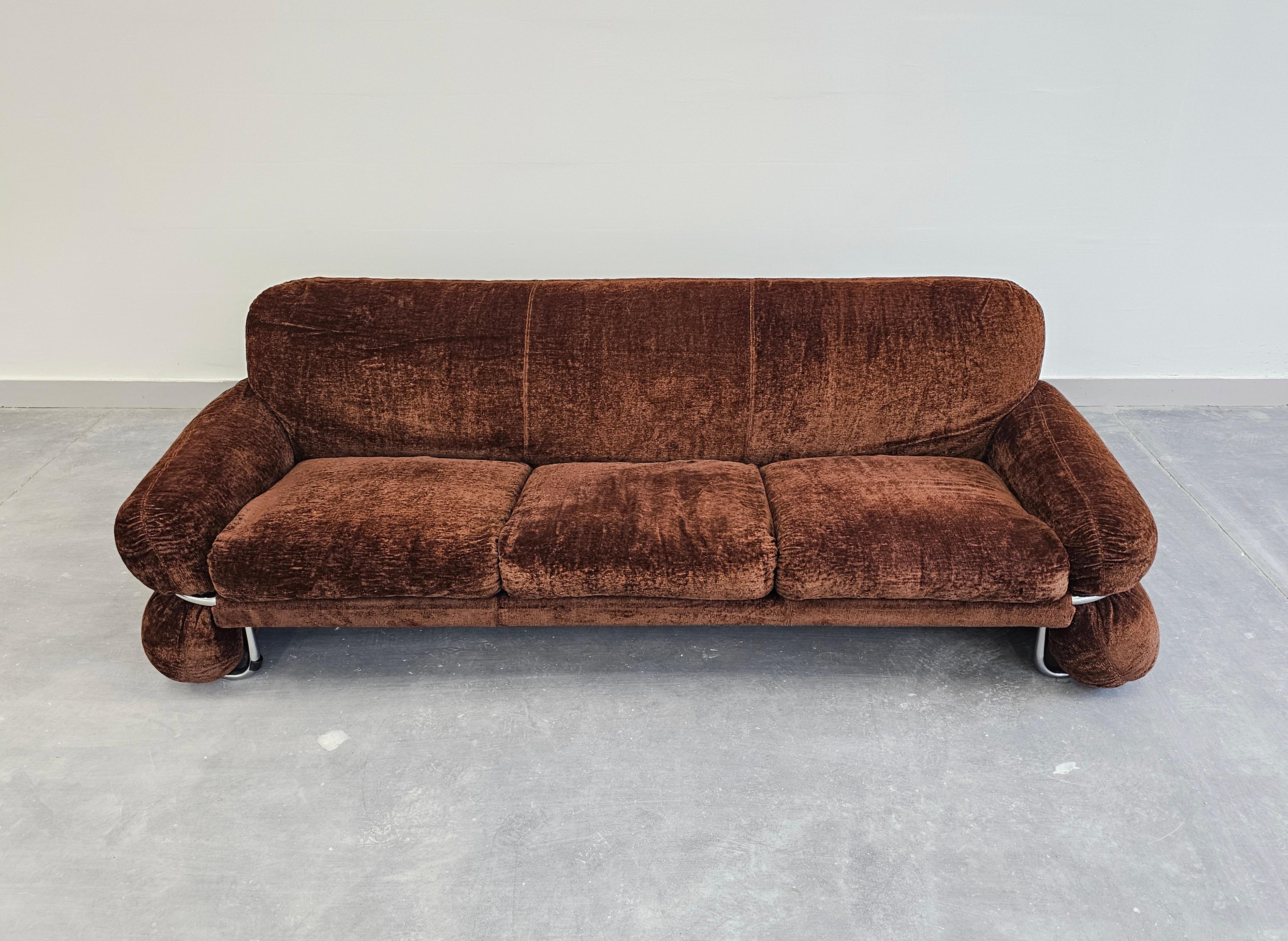 In diesem Angebot finden Sie ein außergewöhnlich seltenes Space Age Sofa mit Rohrrahmen. Dieses originelle 3-Sitzer-Sofa aus braunem Samt im Stil von Gianfranco Frattini besticht durch sein Design und seine Form, die überall, wo Sie es aufstellen,