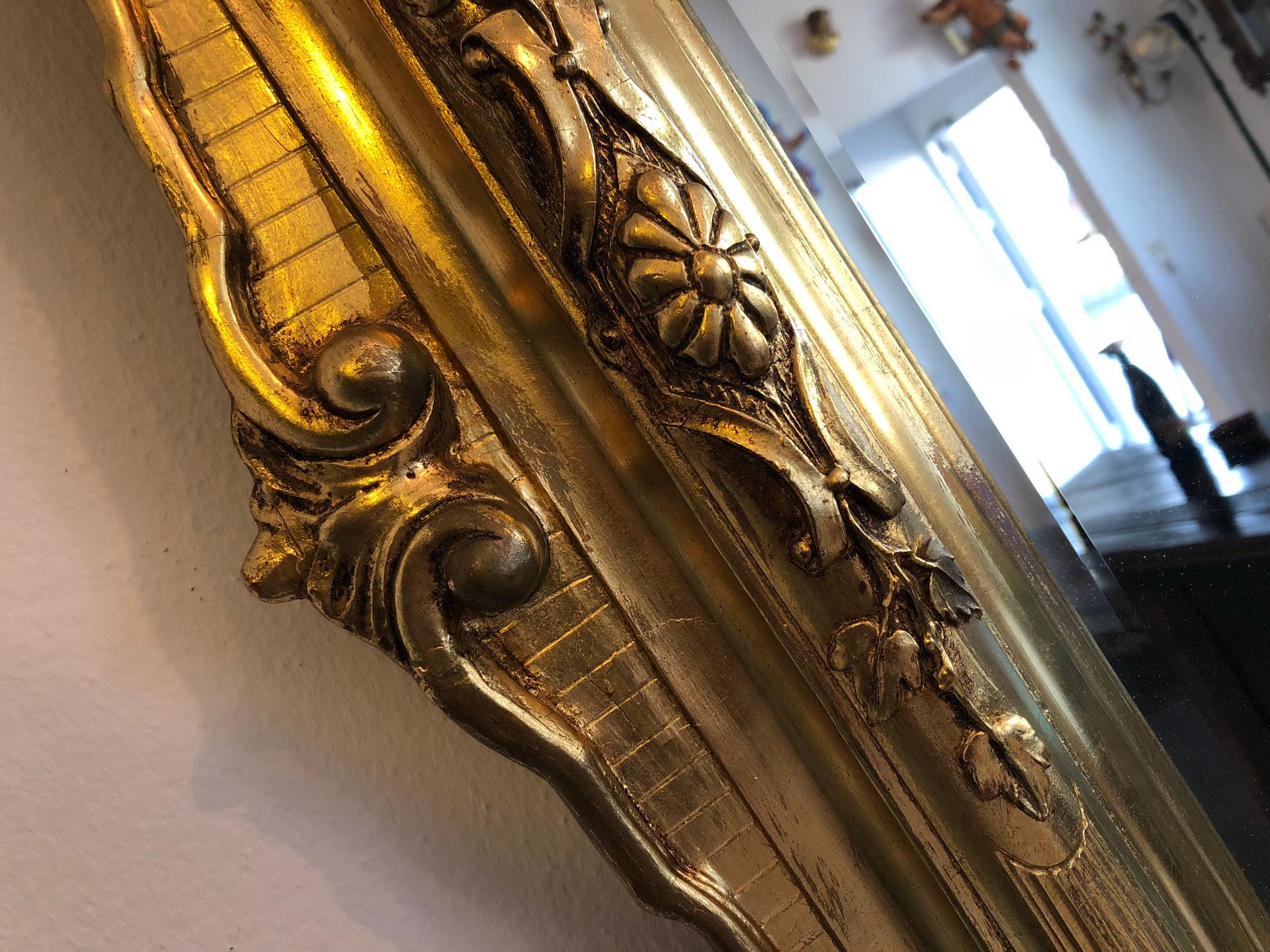 Stunning original gilded Florentine mirror with a carved wooden frame.
Decorated with floral carvings and ornamentations.
The frame is in the original gilded condition (polyment gilding) with slight abrasions
which demonstrates the uniqueness of