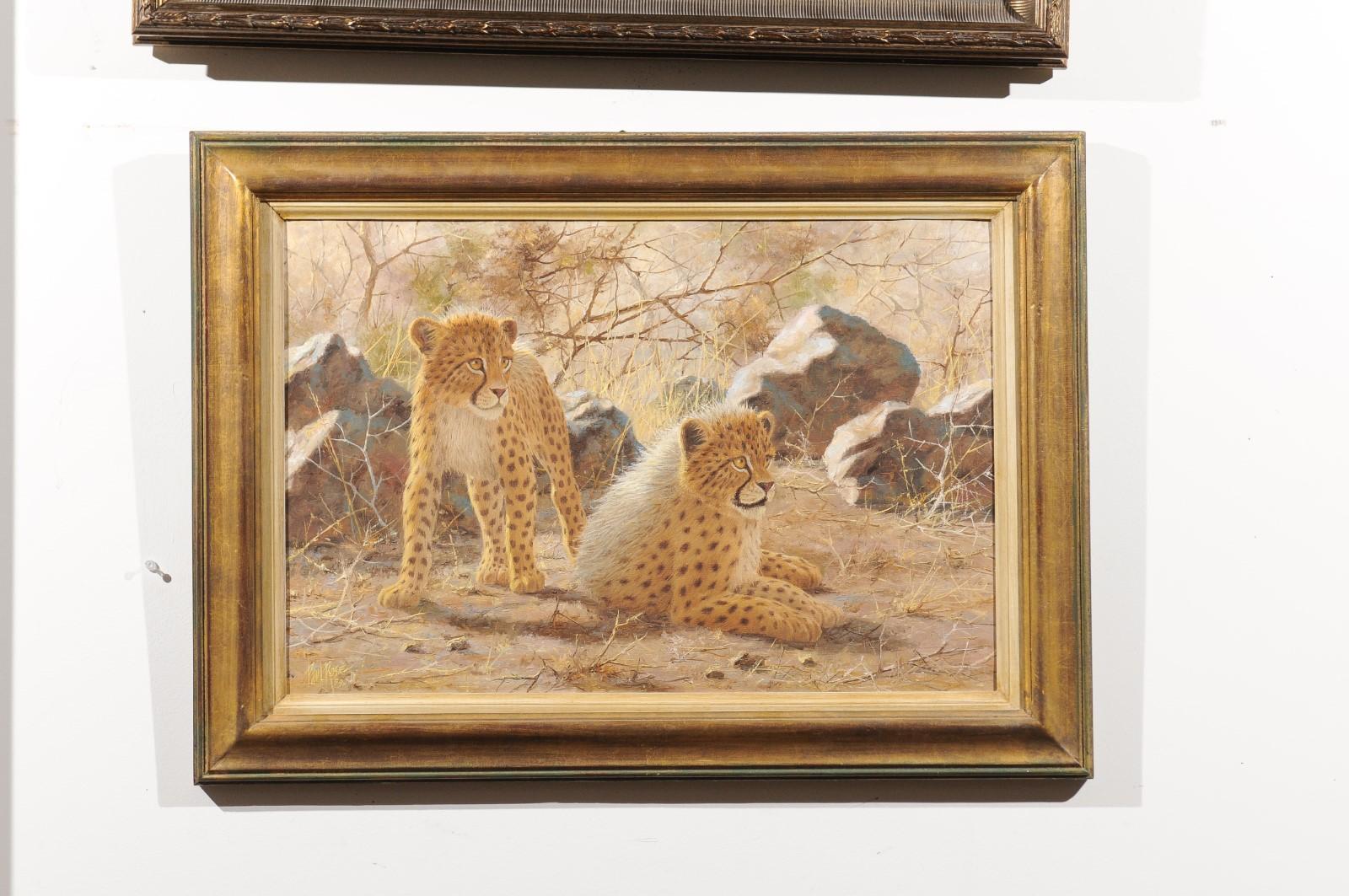 An original Paul Rose framed wildlife horizontal painting from the 20th century, depicting cheetahs. We are immediately subjugated by the two cheetahs depicted in the center of the composition. One of them standing on its paws, the other one
