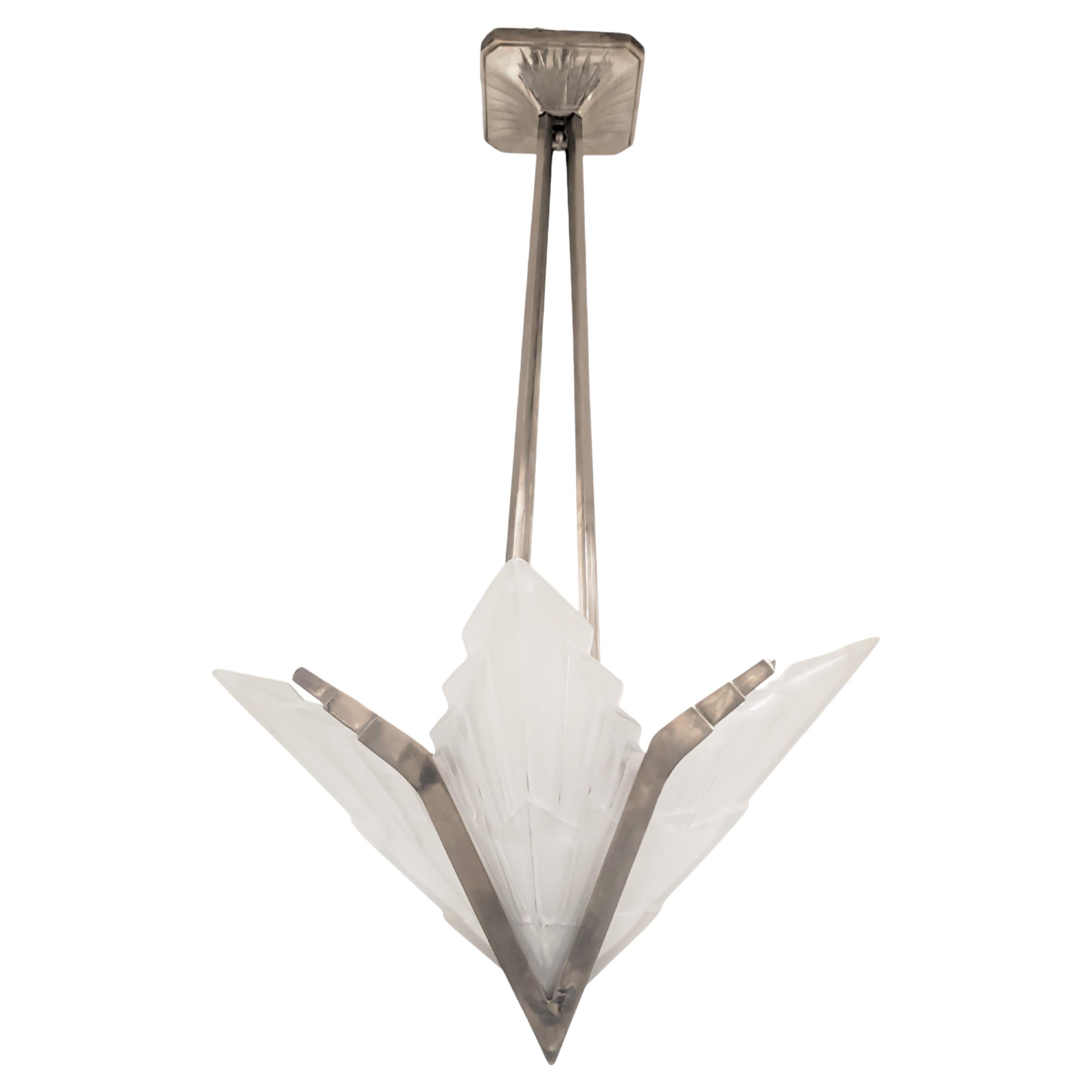 French Art Deco geometric motif chandelier signed Degue featuring four wing shaped frosted and molded art glass panels with chevron design, jagged ends and polished details. 
The architectural panels jut upward and outward in an unusual star