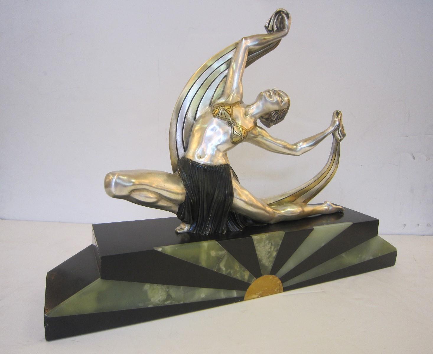 An important French Art Deco parcel-gilt, nickel and polychromed bronze sculpture of a female dancer by J. Lormier.
The figure wearing a bra-like bodice and pleated skirt is portrayed as a dancer, kneeling with graceful scarf overhead in the style