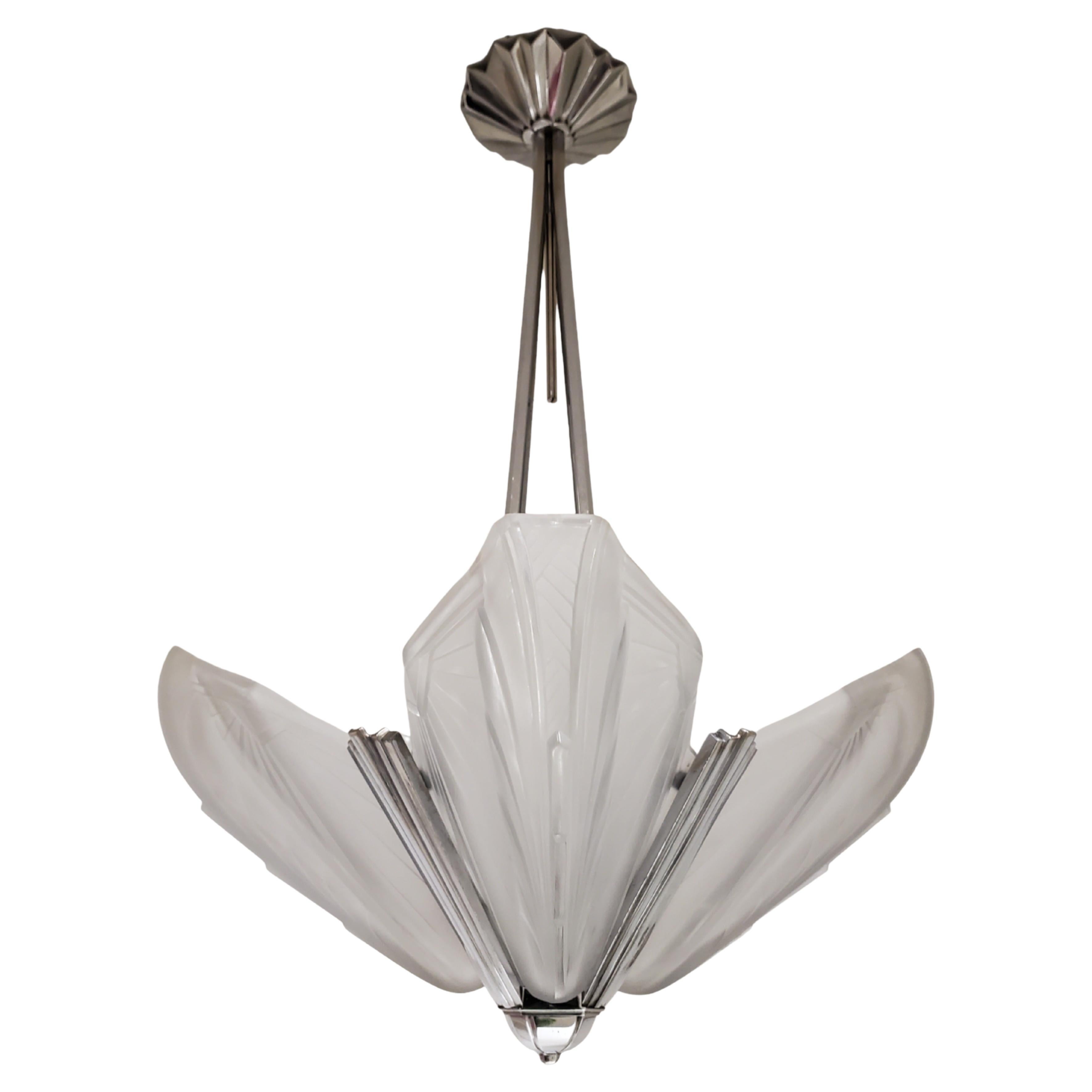 A striking and original French Art Deco period chandelier signed: EJG France featuring a highly stylized blossom design with four petal shape frosted art glass panels, each having a sunray motif and detailed geometric patterns. 
The frosted art