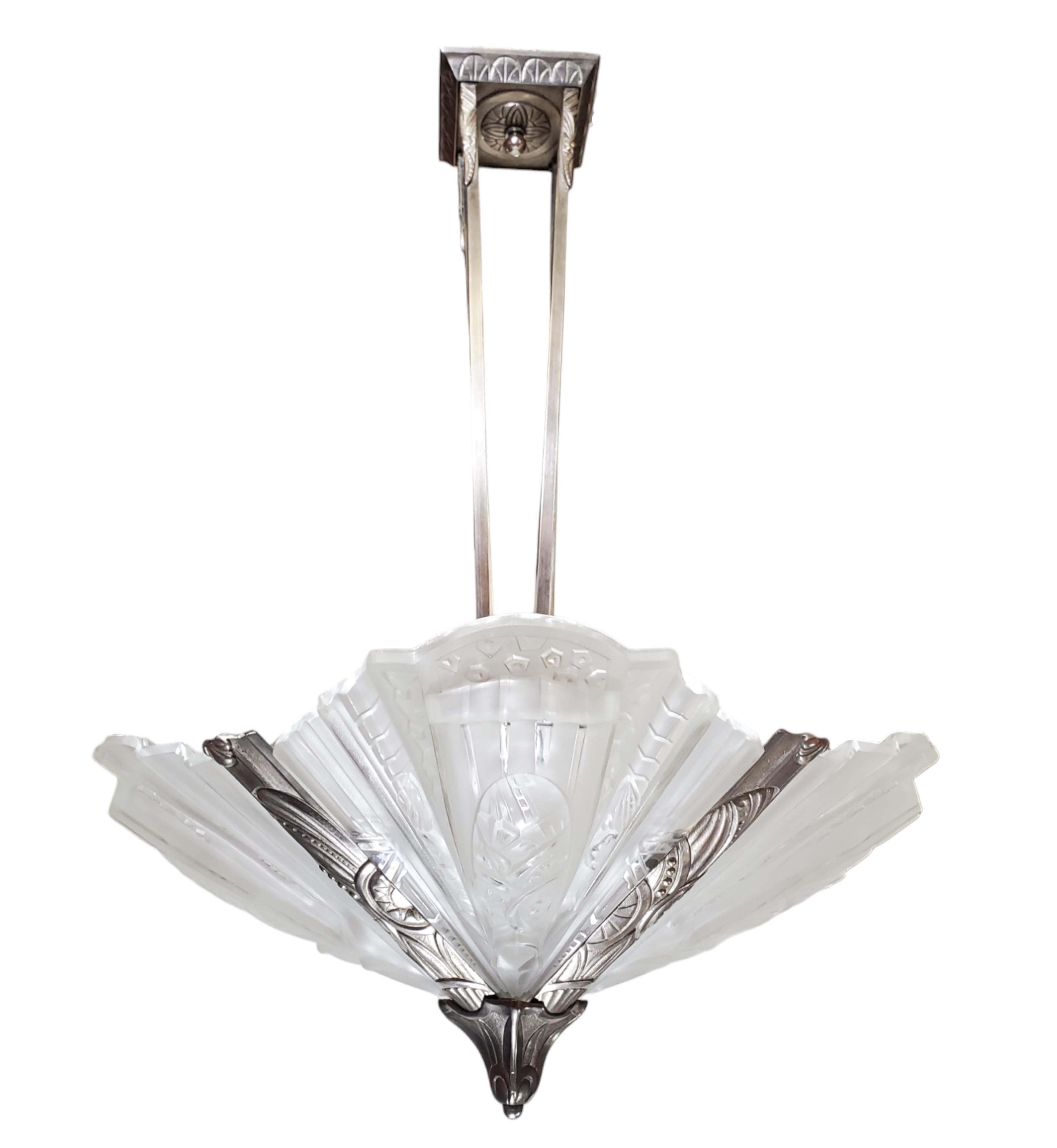 
A fabulous original French Art Deco chandelier with four large and bulbous fan shaped geometric motif frosted art glass panels, mounted in its matching motif decorative nickeled bronze frame; signed Frontisi 
The stepped and fluted architectural