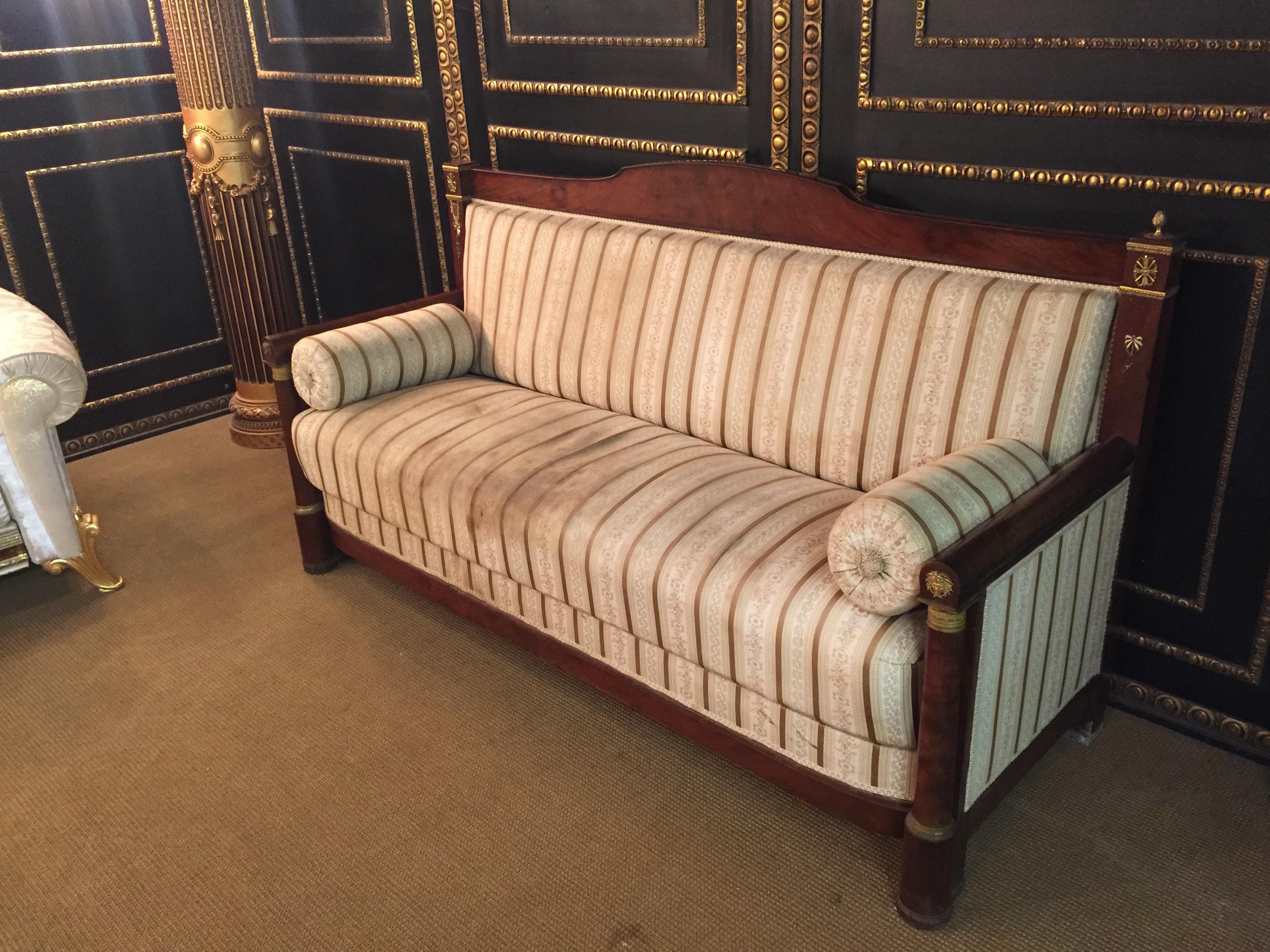 Original French Empire sofa, circa 1800.
Mahogany,
right and left, each with columns and fire-gilt bronze fittings.

Some bronze are missing.

Polstereung would have to be renewed on request we can do that for you.