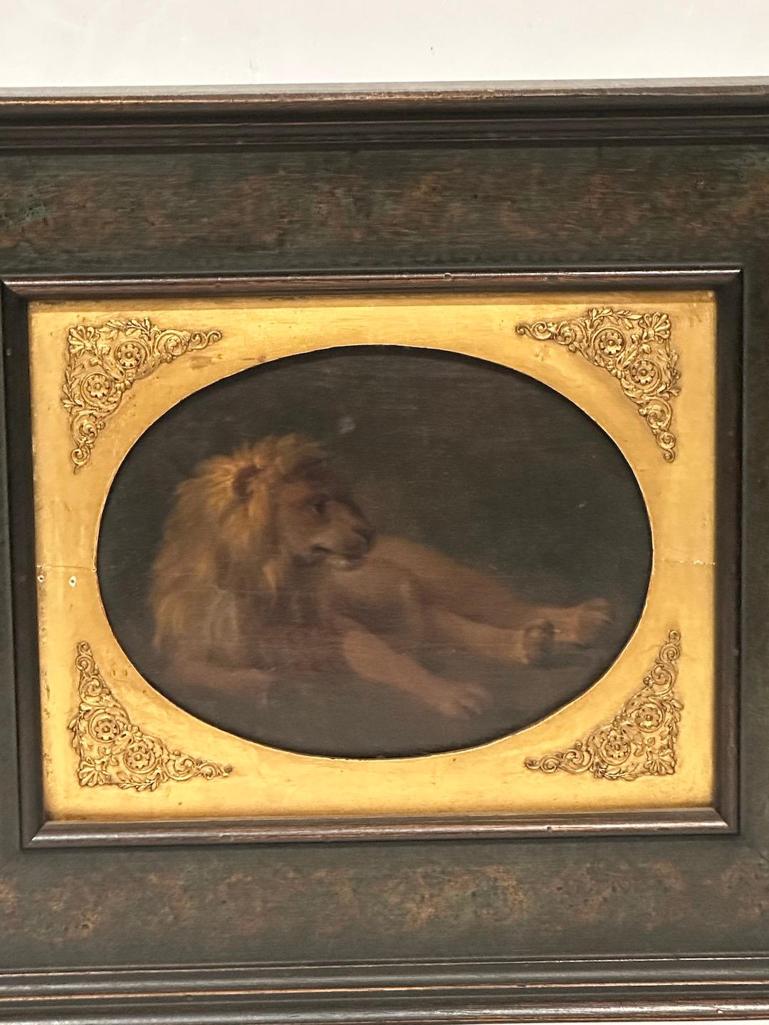 Beautifully painted, oil-on-panel picture of a recumbent lion in its original, gilded wood frame, now enclosed with a newer hand-painted frame.