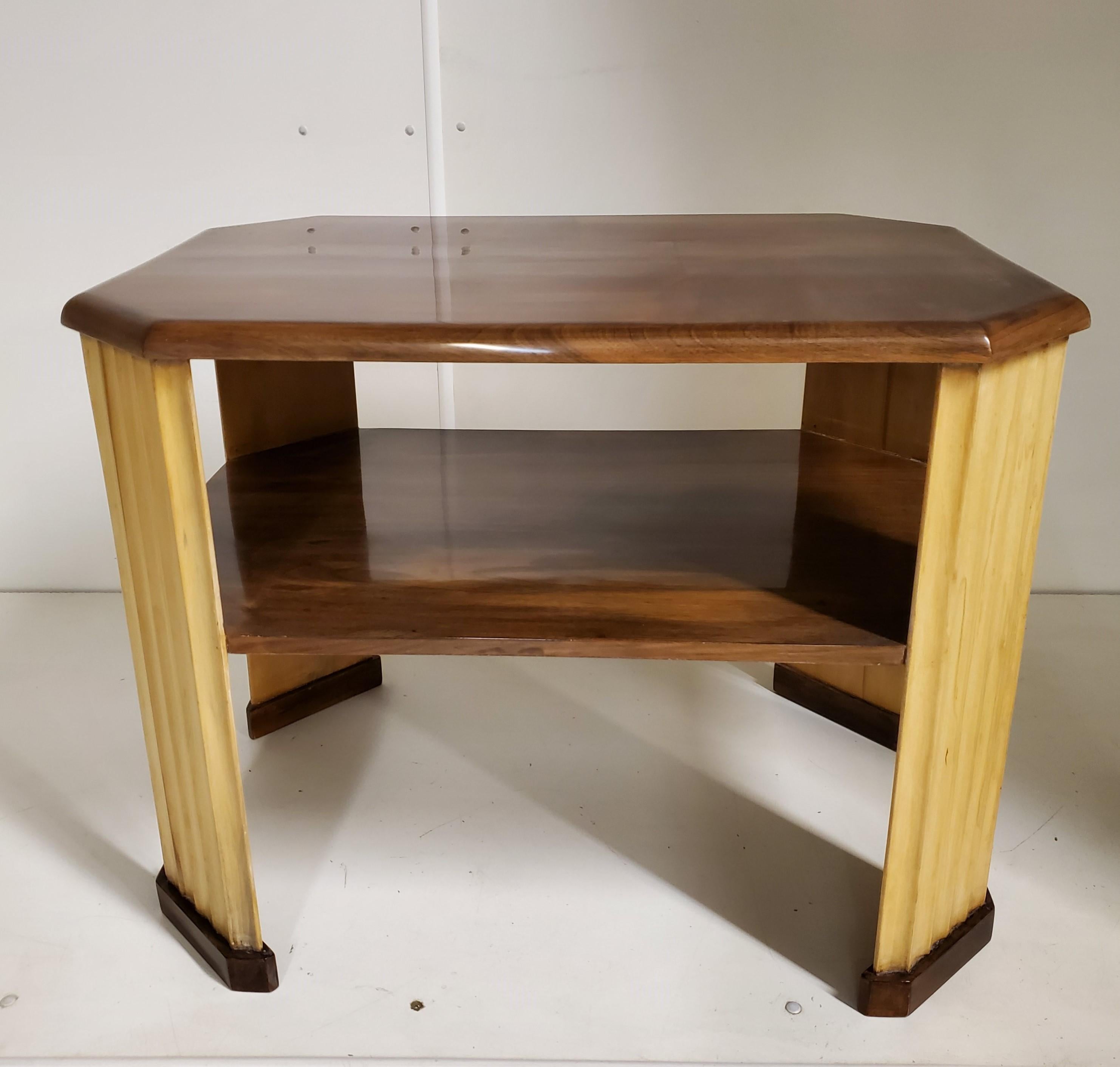 A French Art Deco end table in walnut and blond wood featuring four fluted legs supporting an inlaid parquetry top and co-joined by a stretcher shelf.
Functionality, practicality and beauty all in one!
This exquisite table can be used as a