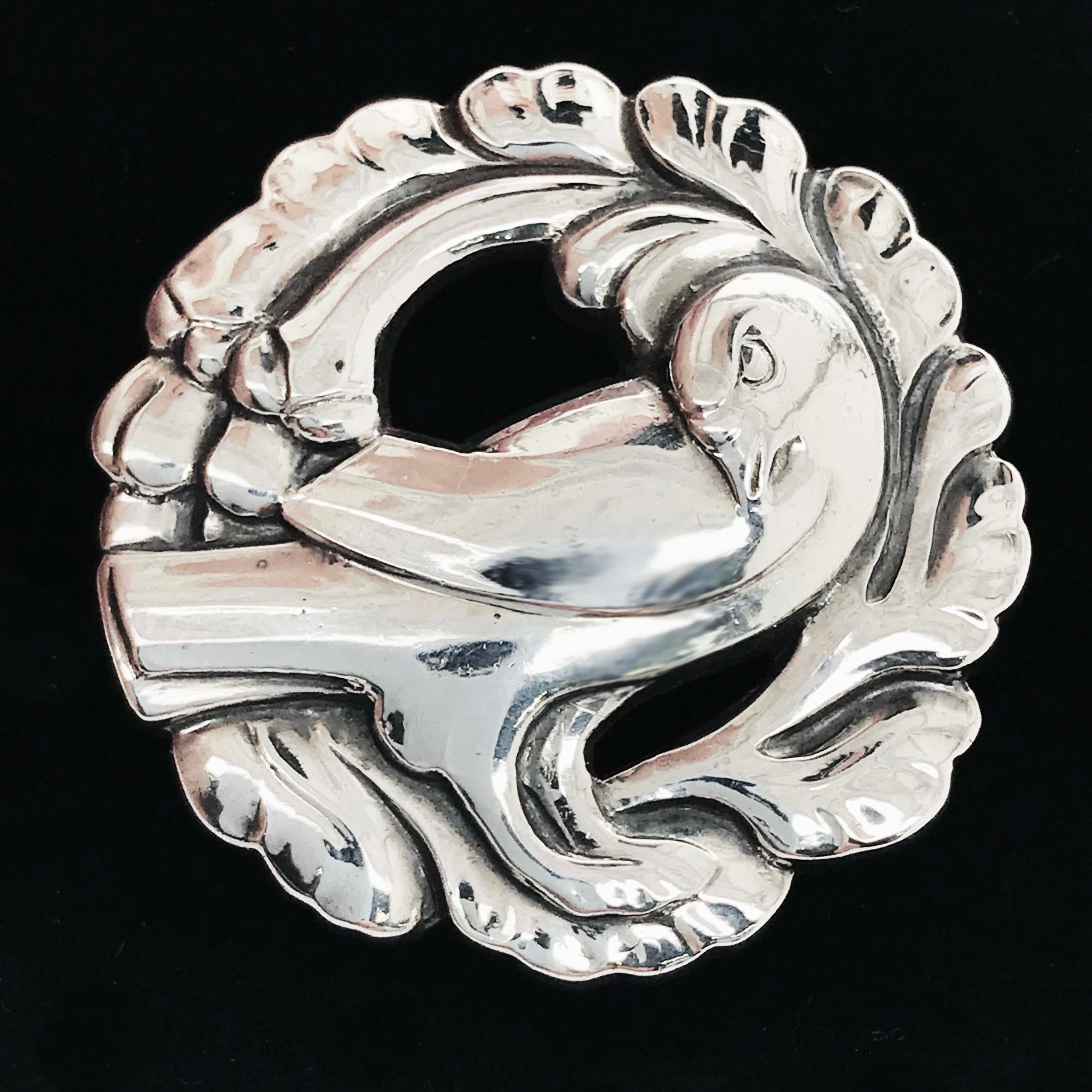 The genuine vintage Georg Jensen dove brooch is an antique fine jewelry piece pre 1945. Georg Jensen is a famous jewelry designer located in Copenhagen, Denmark. He was known for his Scandinavian, Art Nouveau designs and creations. This sterling