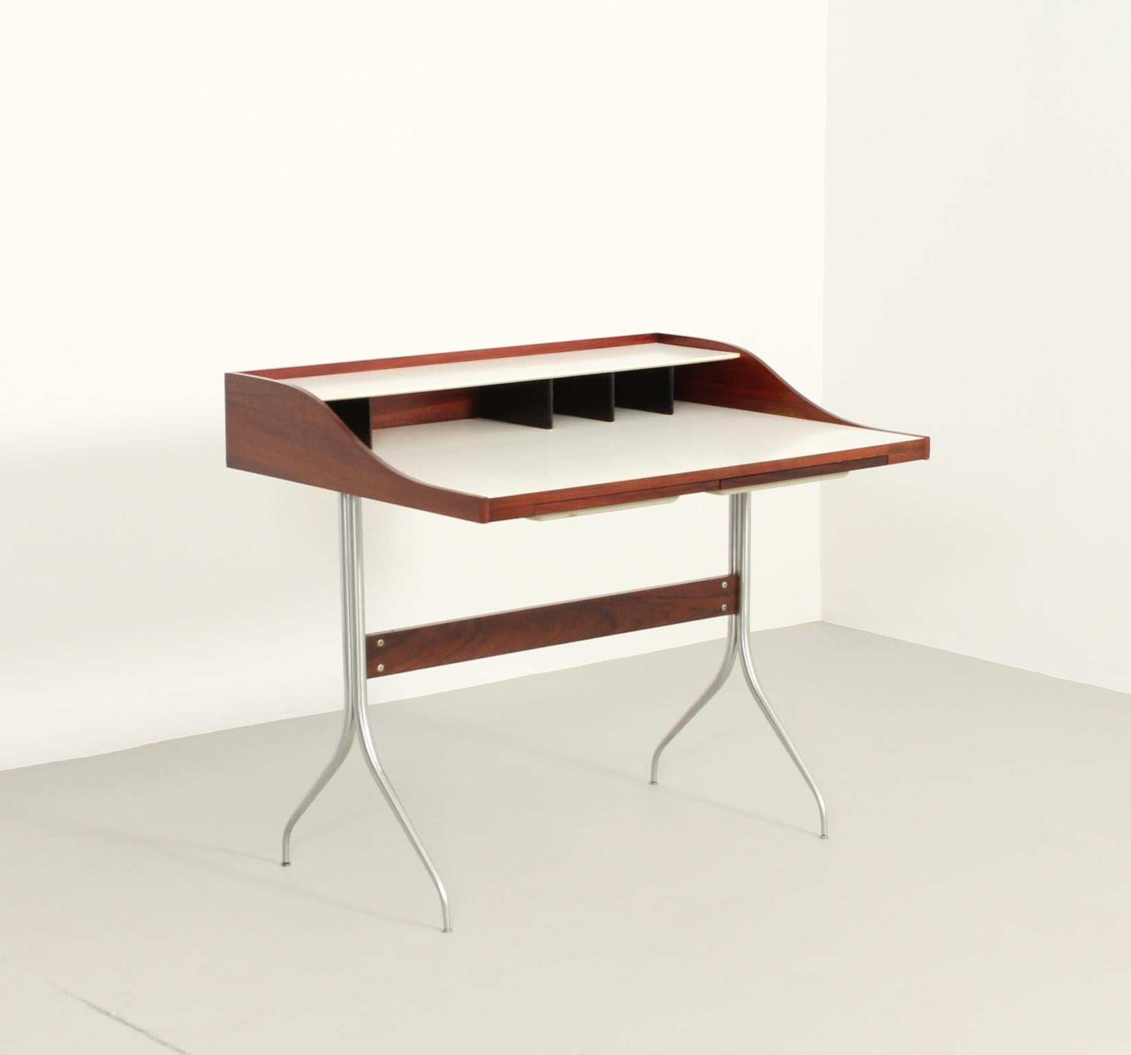 Sawg leg desk model 5850 designed in 1954 by George Nelson for Herman Miller, USA. Original edition in rosewood wood and white laminate with two molded plastic drawers, bases in polished steel.