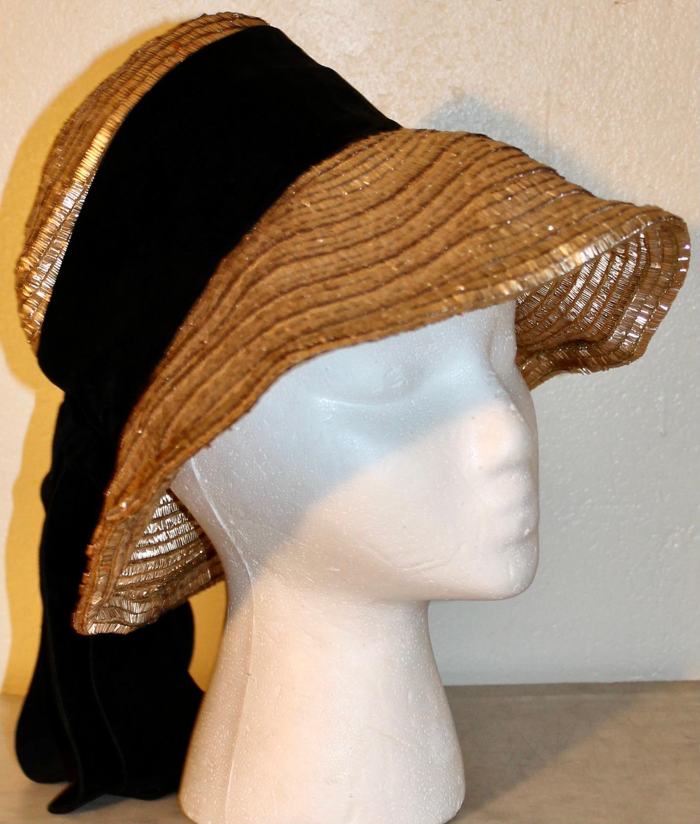 Offering an original Gerard d'Albouy (1912-1985) woven brass hat with a Velvet Ribbon attached.  The Paris Milliner, during the German Occupation (active 1938-1964) was noted for his exciting and original uses of unusual materials: such as recycled